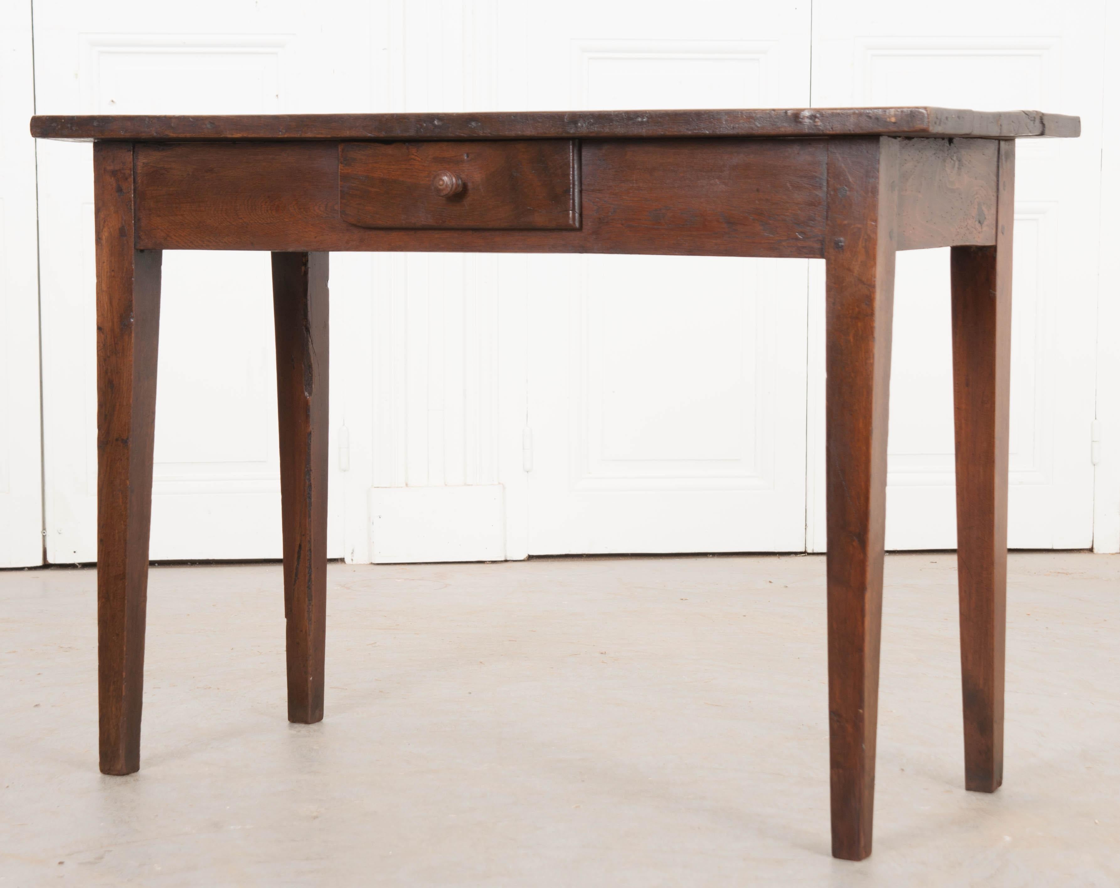 This handsome English oak server, circa 1870, features a plank surface over a narrow apron outfitted with a single short drawer and having a turned wooden pull. The whole rests upon square tapering legs. This server would work well in a dining area