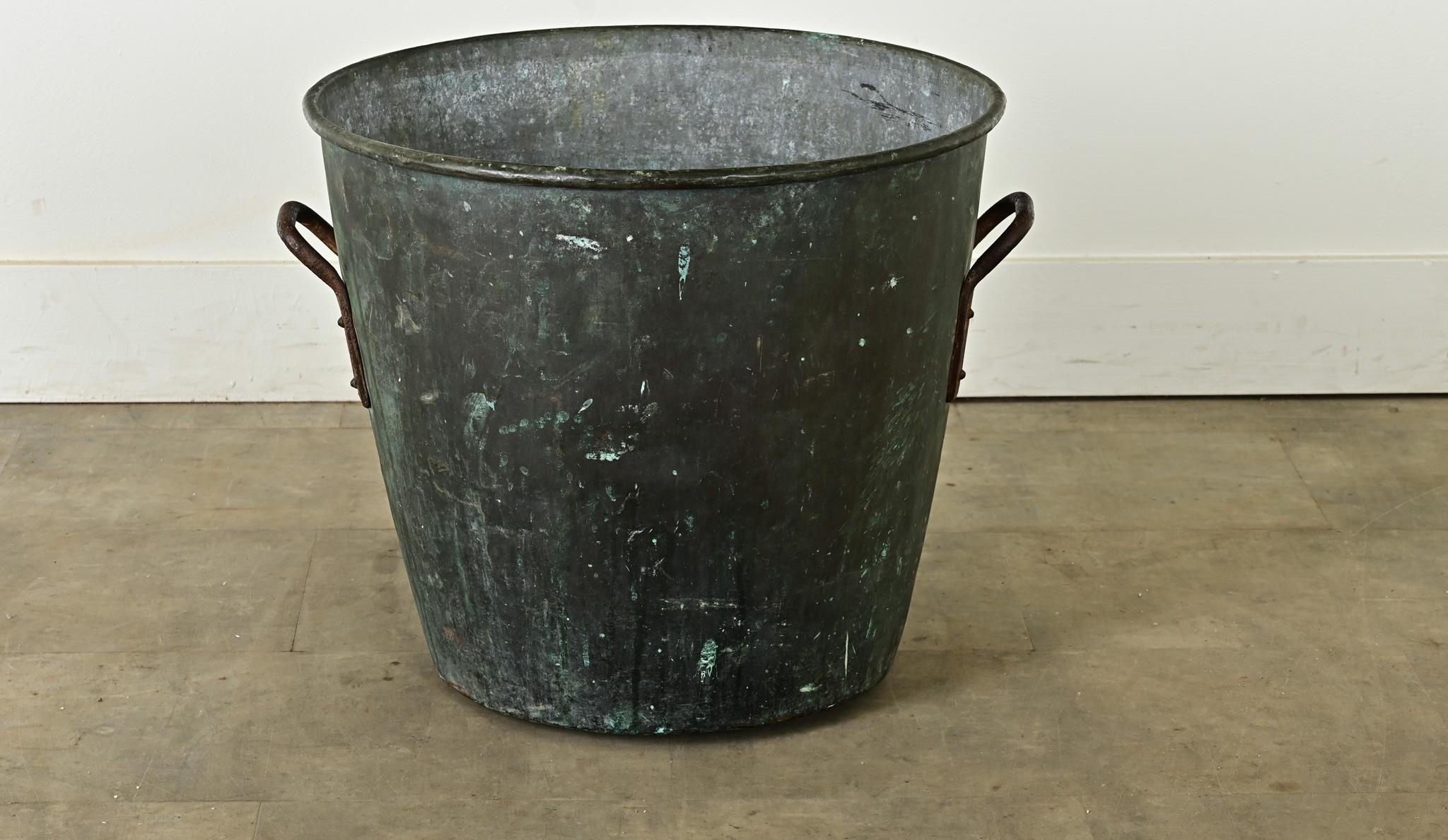 Importante marmite anglaise en cuivre, datant d'environ 1850. Le récipient conique est fortement oxydé, seules les poignées étant encore reconnaissables comme étant en cuivre. Le vert-de-gris excitant raye le métal avec des éclats de vert.