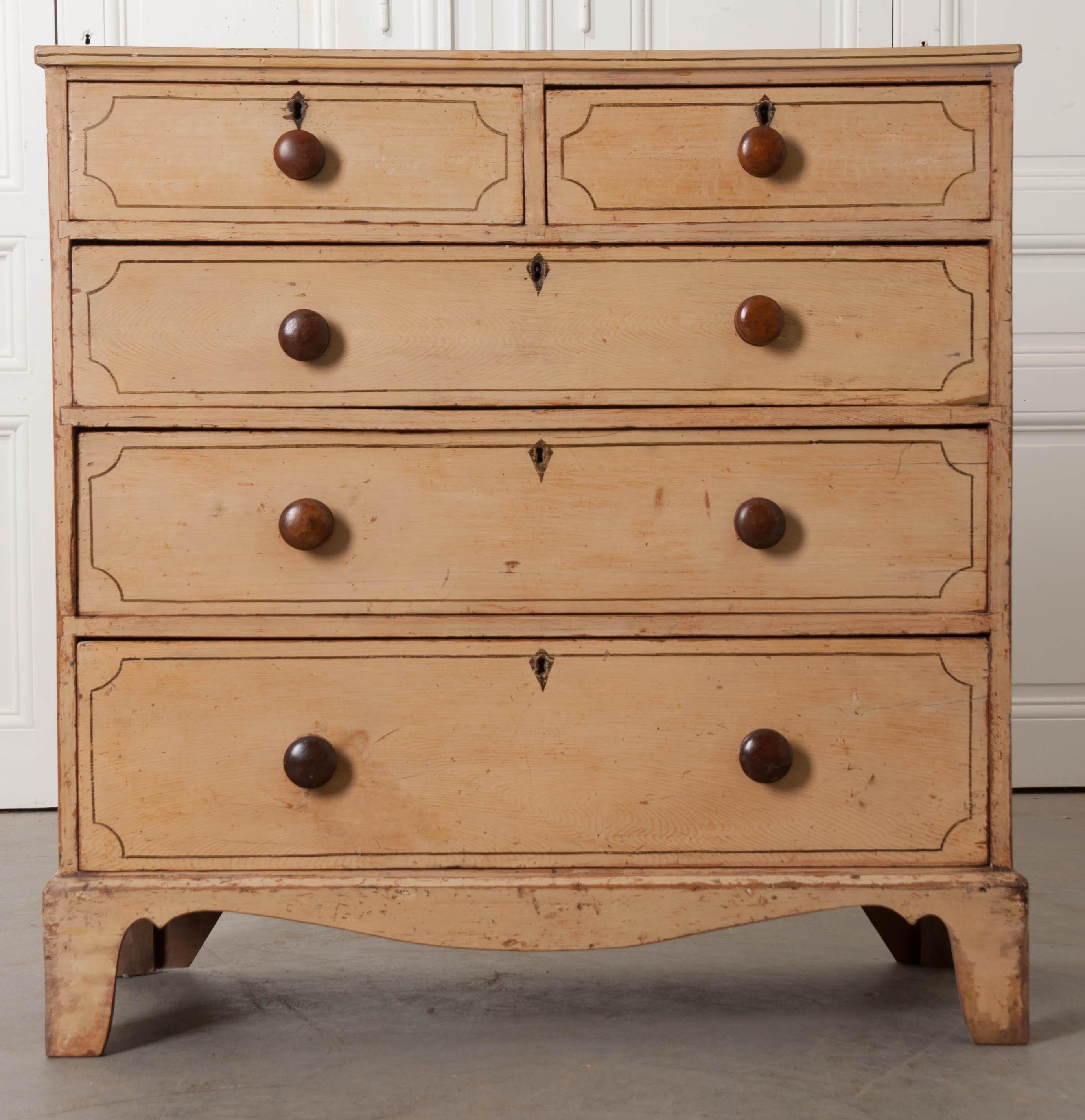 A wonderful painted pine chest of drawers, made in England, circa 1890. This five-drawer chest has been painted with sweet trimmed details, done in a dark brown tone, over a mellow, antiqued creamy yellow. The topmost drawers are half the size of
