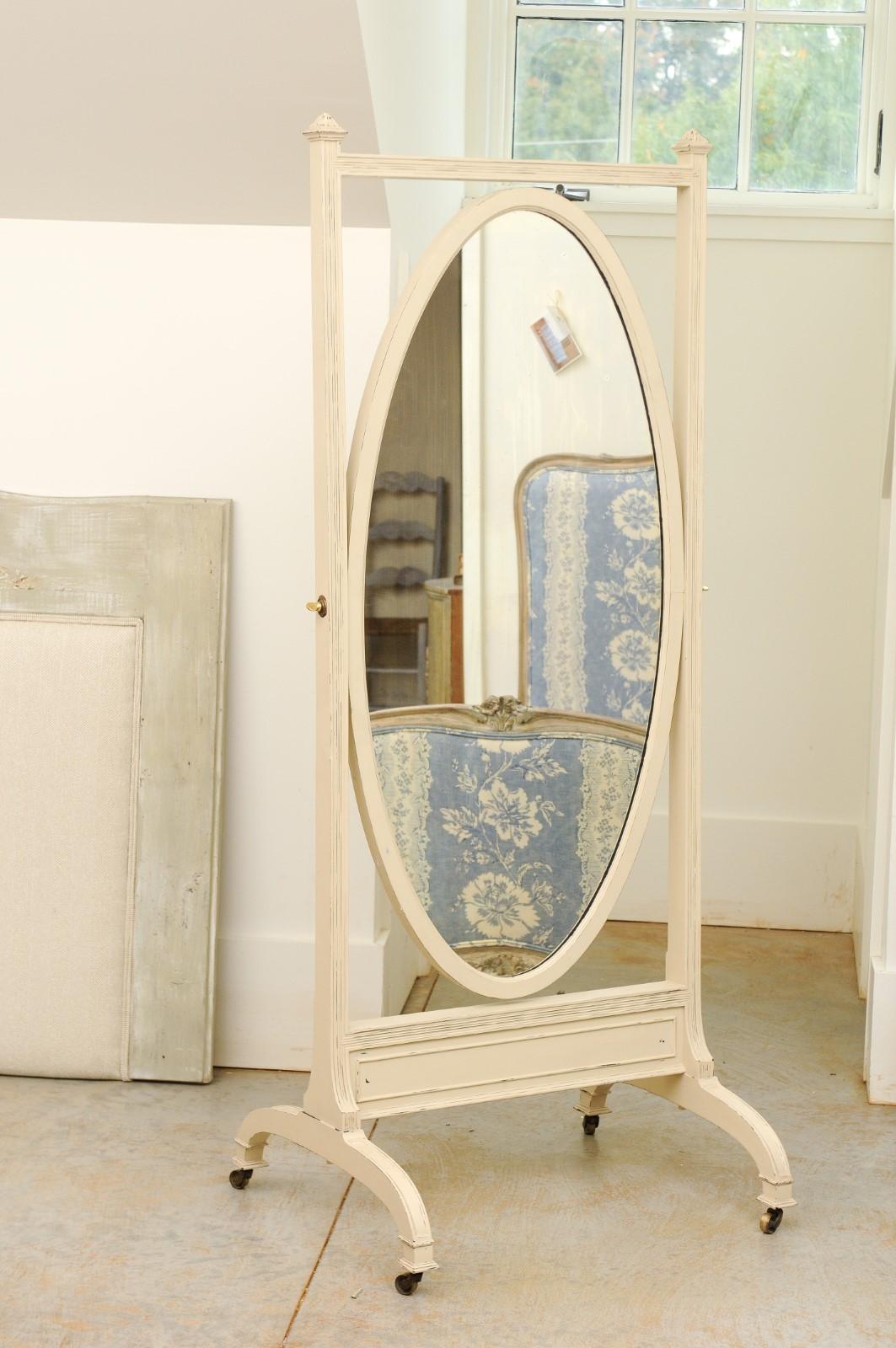 An English painted wood freestanding cheval mirror from the 19th century, with oval mirror plate, curving base and casters. Born in England during the 19th century, this lovely cheval mirror features an oval plate surrounded by a linear frame. The