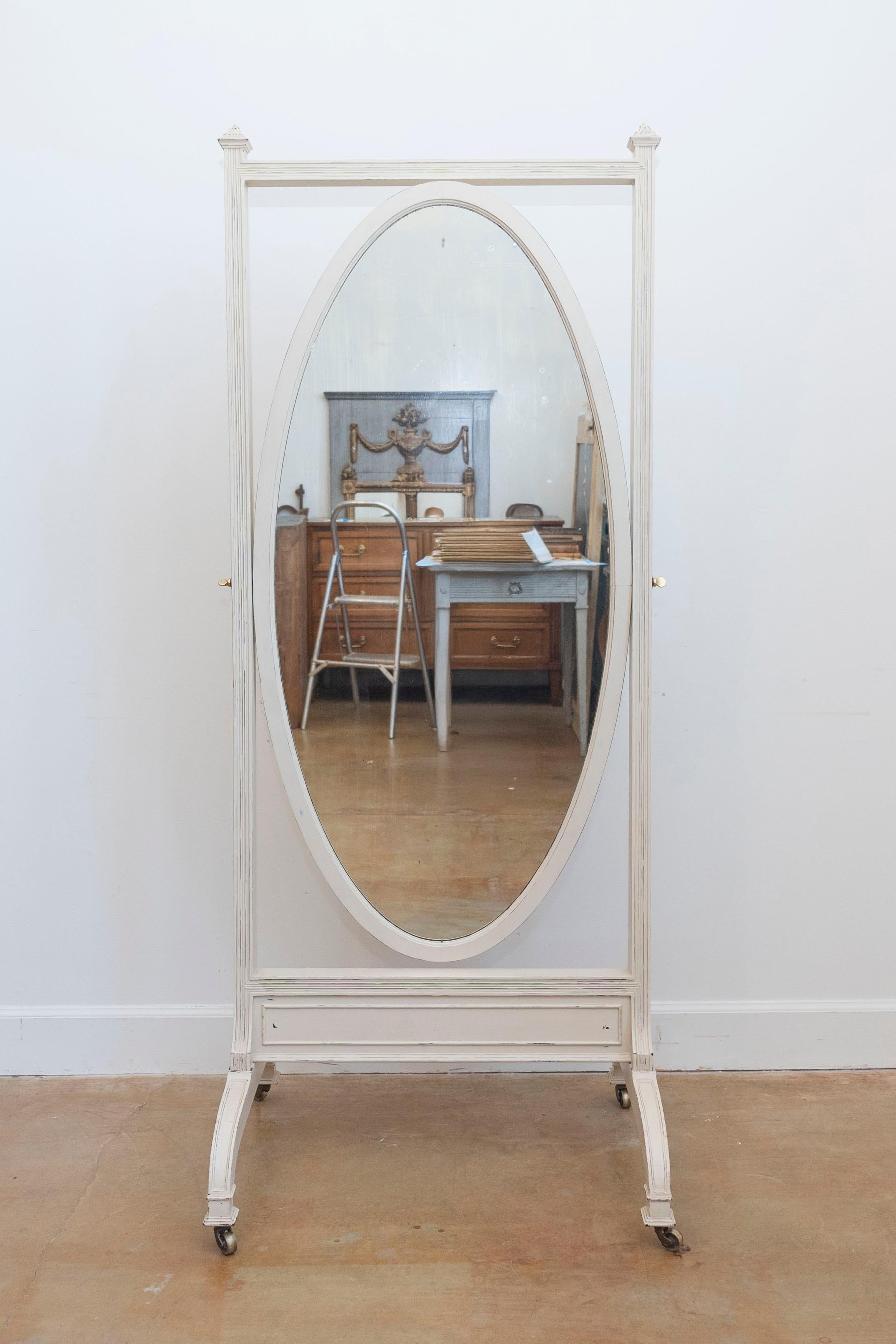 Specchio chevale inglese in legno dipinto del XIX secolo, con piastra ovale, base curva e rotelle. Nato in Inghilterra nel XIX secolo, questo delizioso specchio cheval presenta un piatto ovale circondato da una cornice lineare. Lo specchio