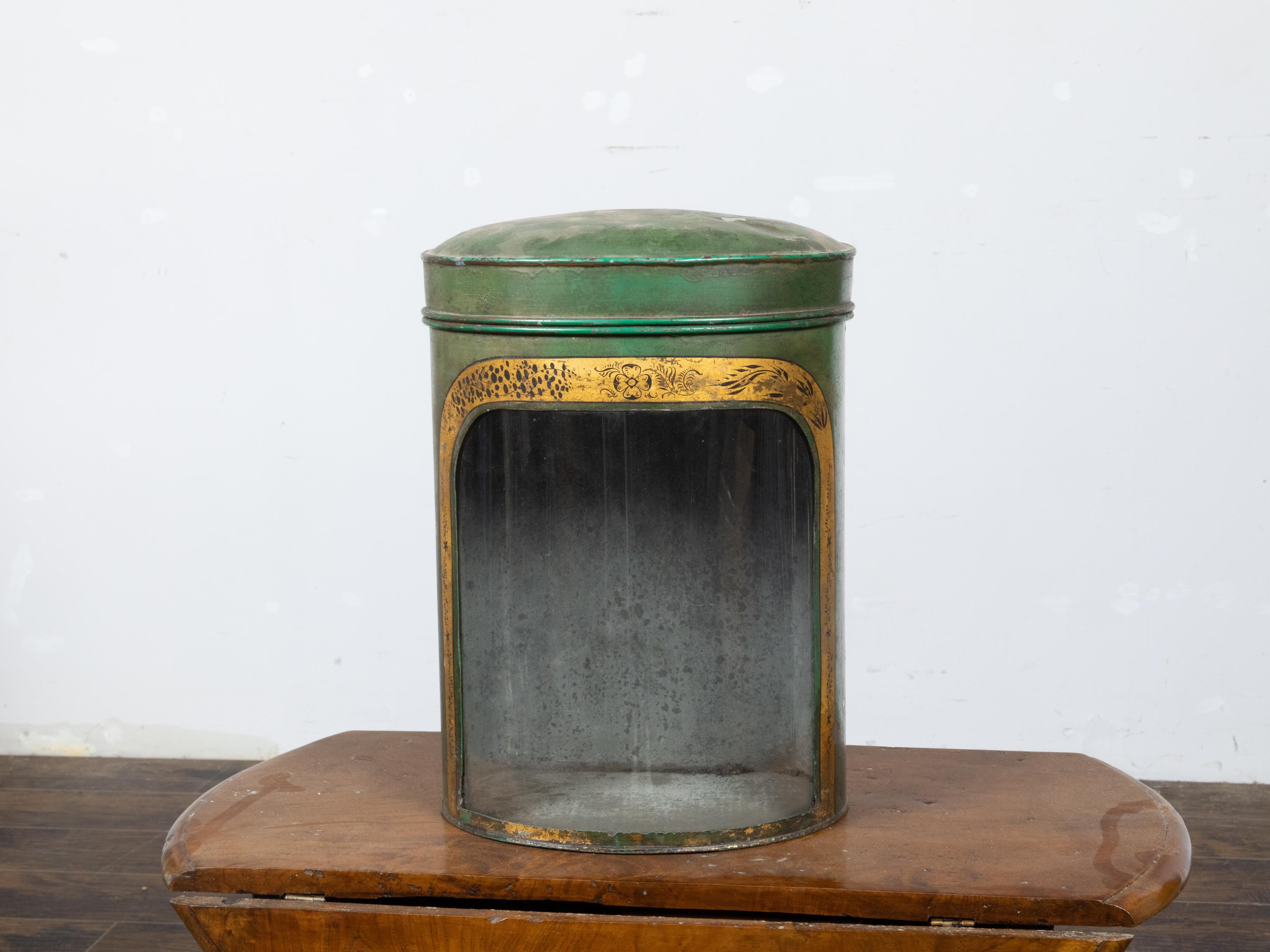 An English Parnall & Son green painted metal tea box from the 19th century with gilt painted floral frieze, glass front flat back and maker's mark. This English Parnall & Son green painted metal tea box, originating from the 19th century, showcases