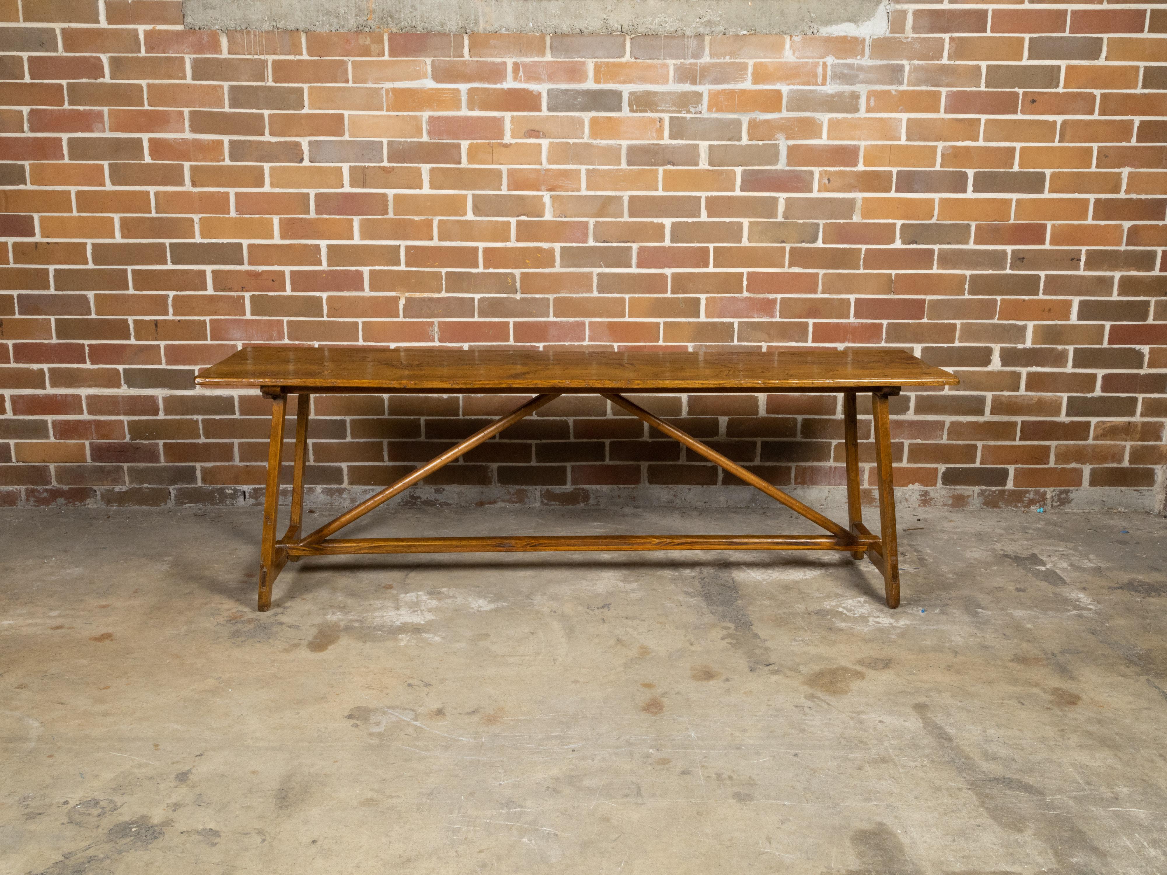 A long English pine console table from the 19th century with trestle base and nicely weathered patina. Created in England during the 19th century, this pine console table features a long rectangular top with good distressing, sitting above a simple