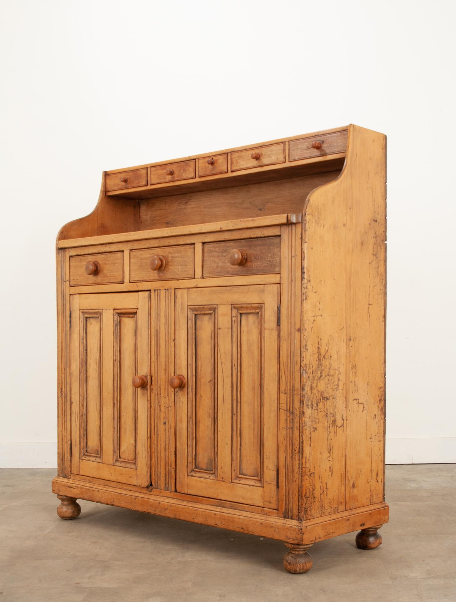 This delightful English pine dresser was made circa 1840 and is brimming with country charm. The warm tones found within the antique pine are absolutely beautiful and naturally comforting. The English pine has accumulated a patination that is second