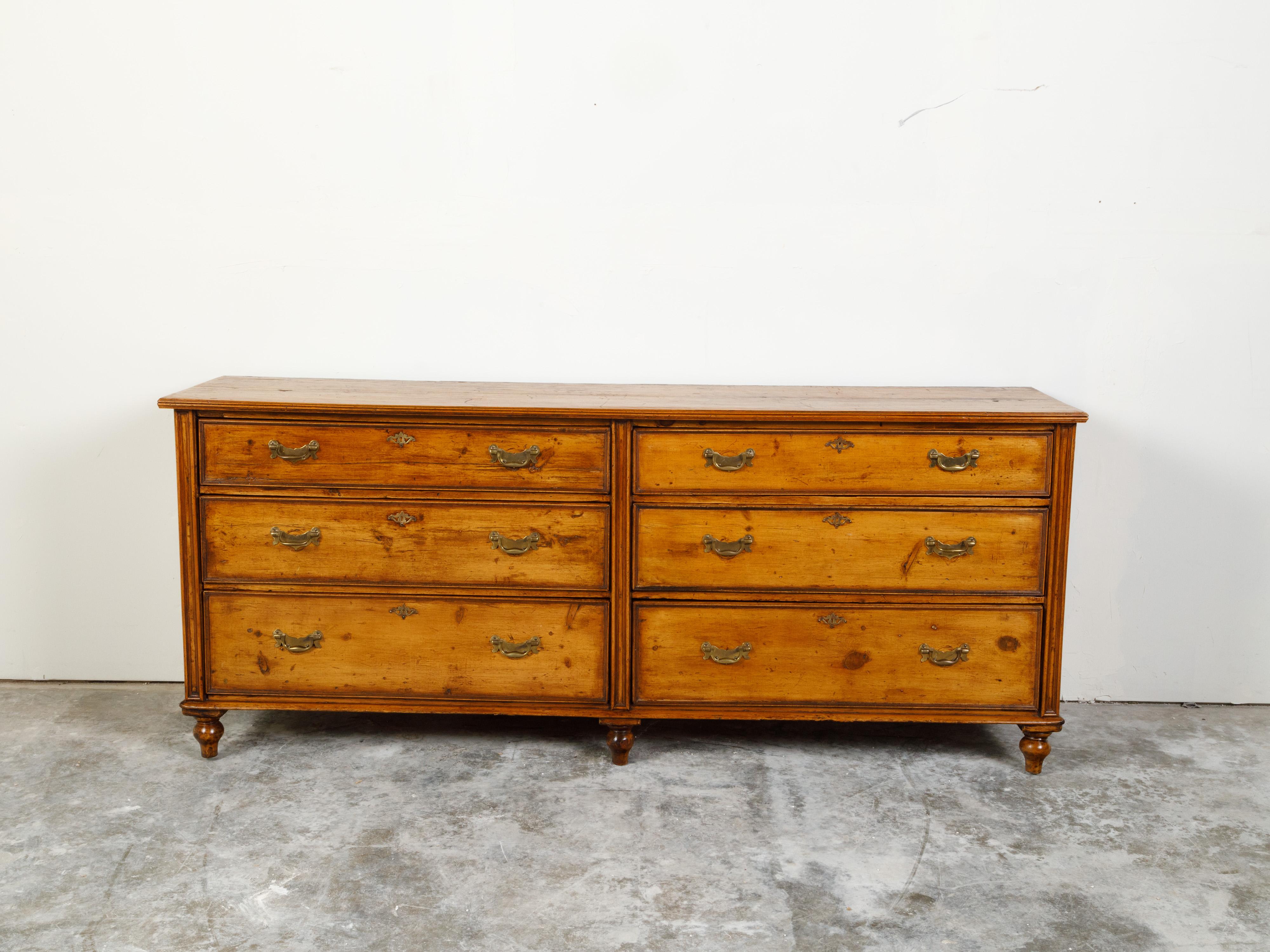 An English pine dresser from the 19th century, with six graduated drawers and brass hardware. Created in England during the 19th century, this pine dresser features a rectangular top sitting above three graduated drawers fitted with brass hardware