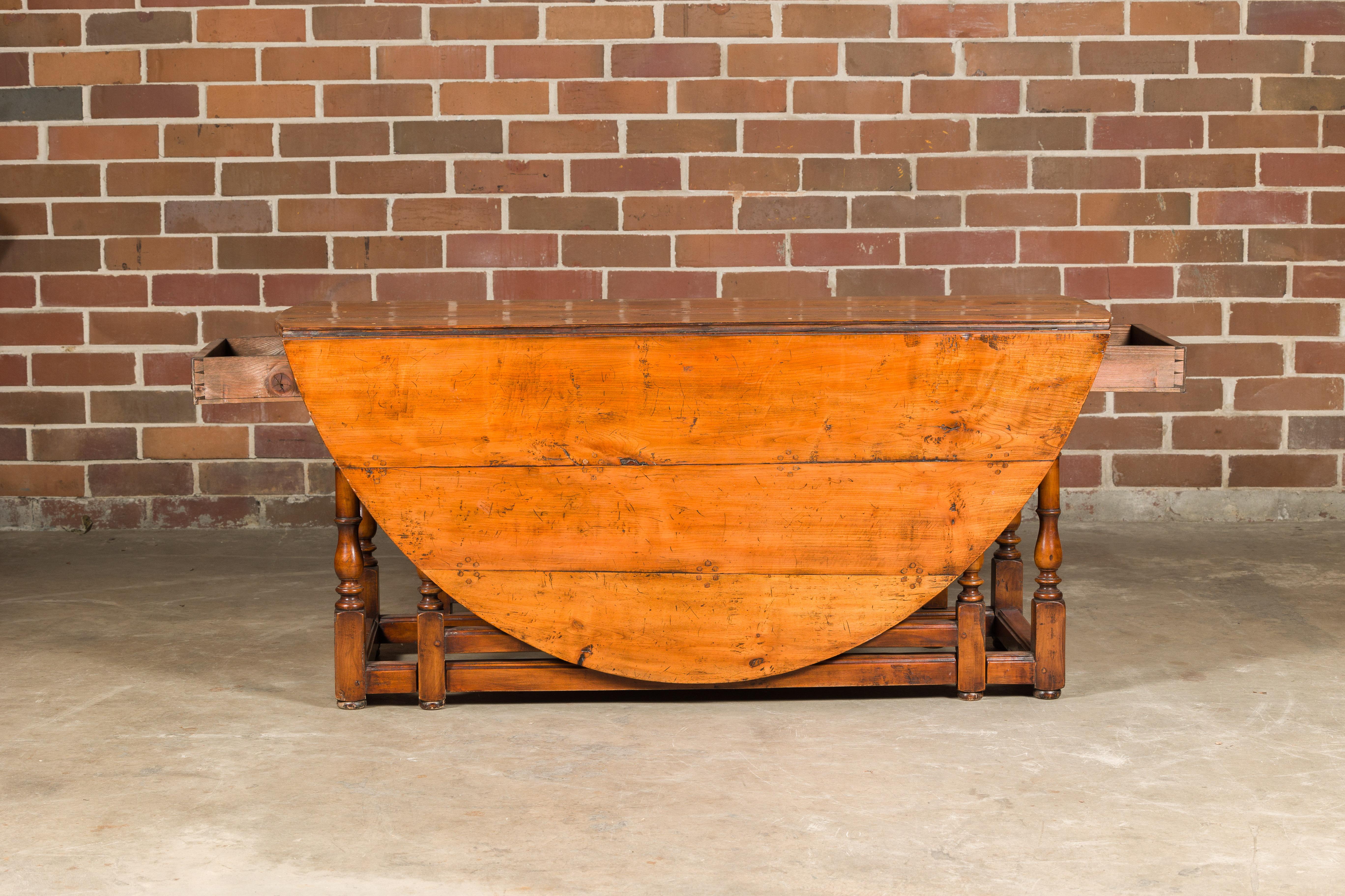 Rustic English 19th Century Pine Drop-Leaf Table with Oval Top and Turned Legs For Sale