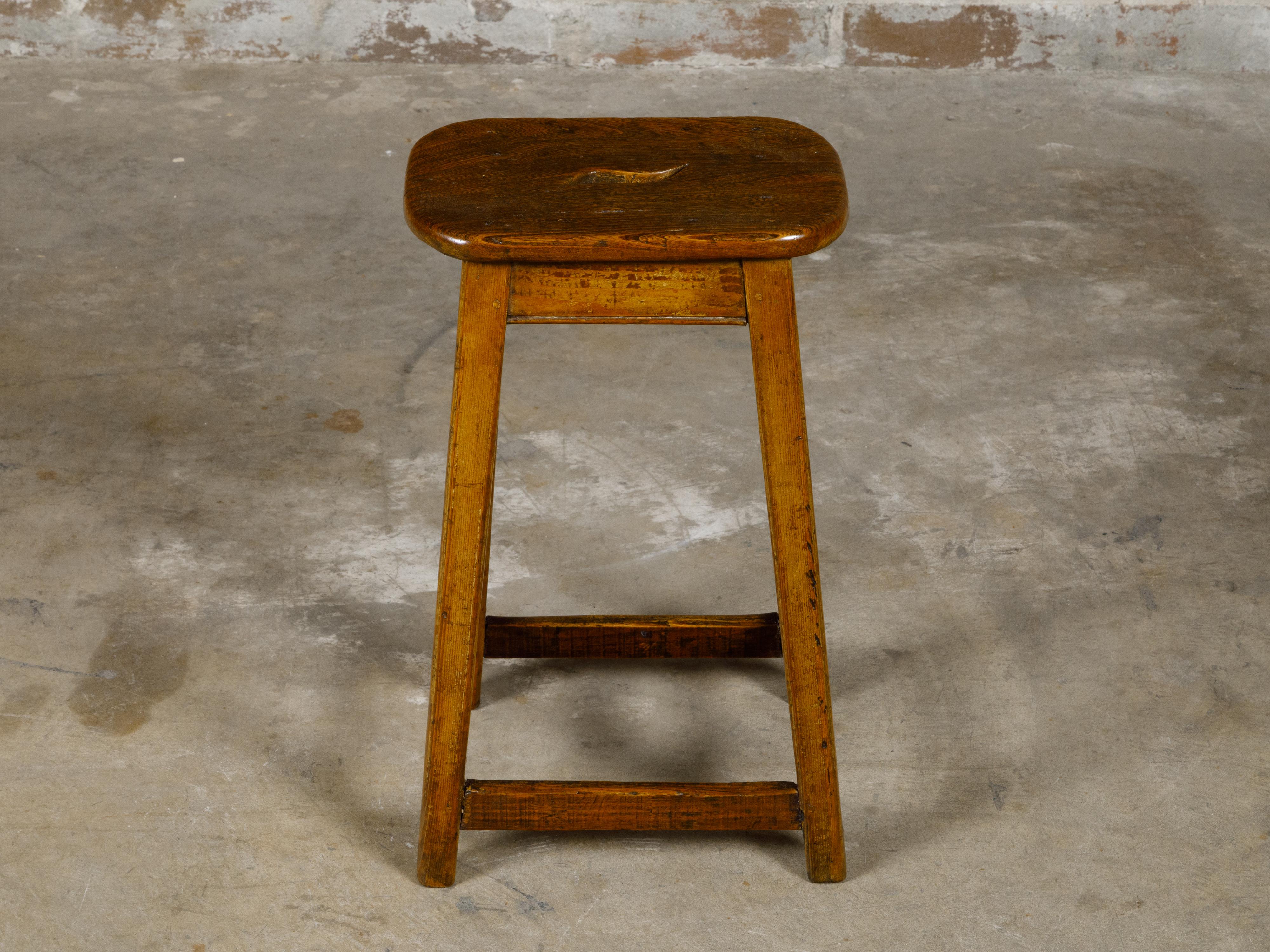 An English 19th century pine stool with side stretchers and rustic character. Discover the rustic charm and practicality of this English 19th-century pine stool, a piece that beautifully showcases the simplicity and robustness of traditional