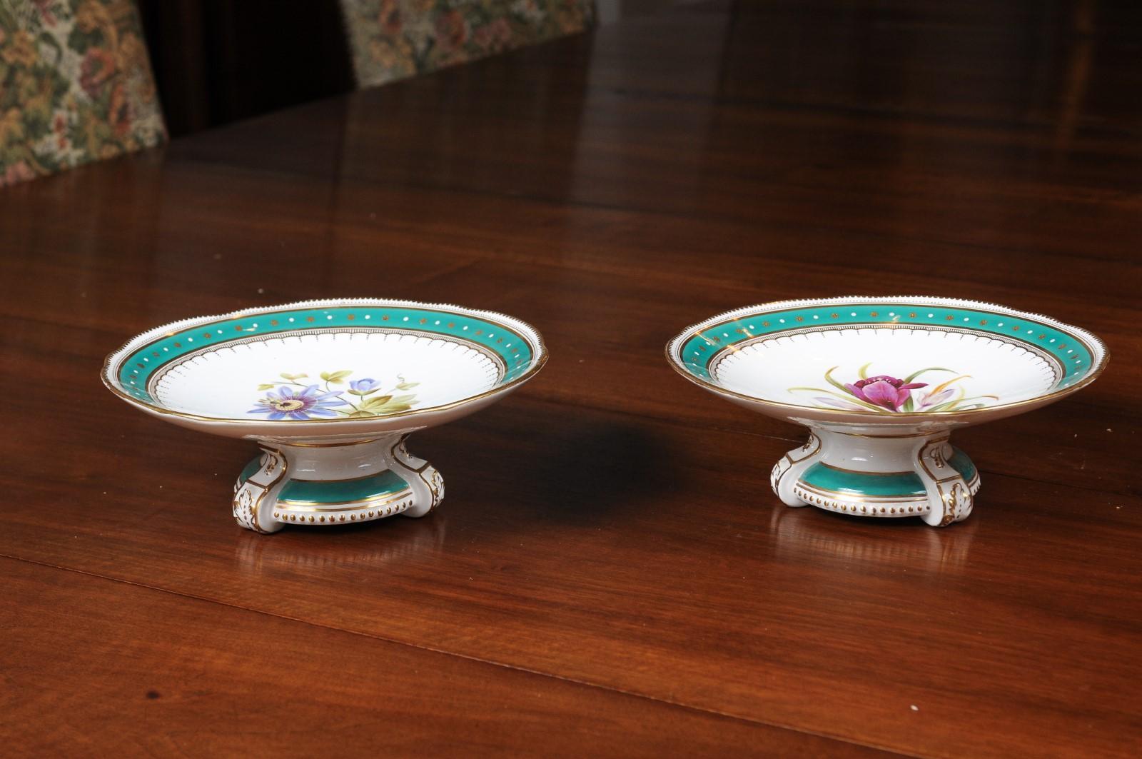 English porcelain compotes from the 19th century, with floral motifs and green borders. We currently have two available, priced and sold individually. Born in England during the 19th century each of these two compotes attracts our attention with its