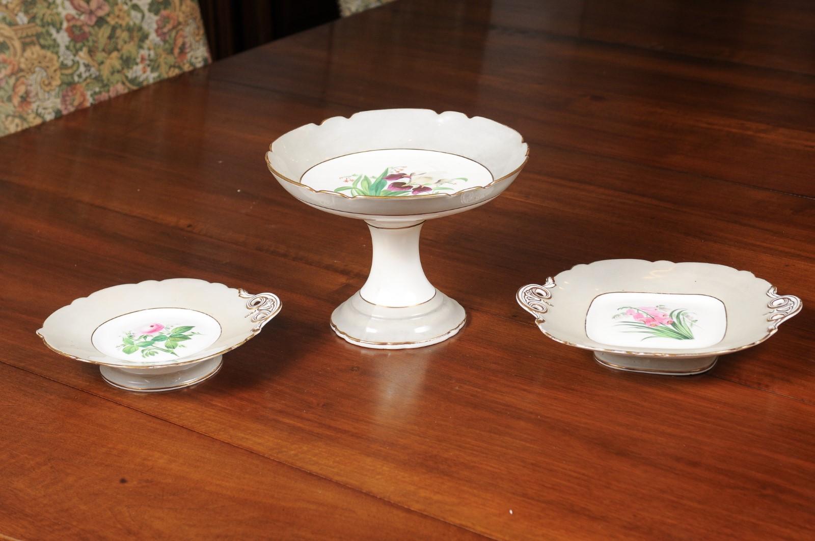 English porcelain plates and compote from the 19th century, with floral décor, priced and sold individually. Born in England during the 19th century, each of these serving dishes features a pink and green floral décor standing out beautifully on a
