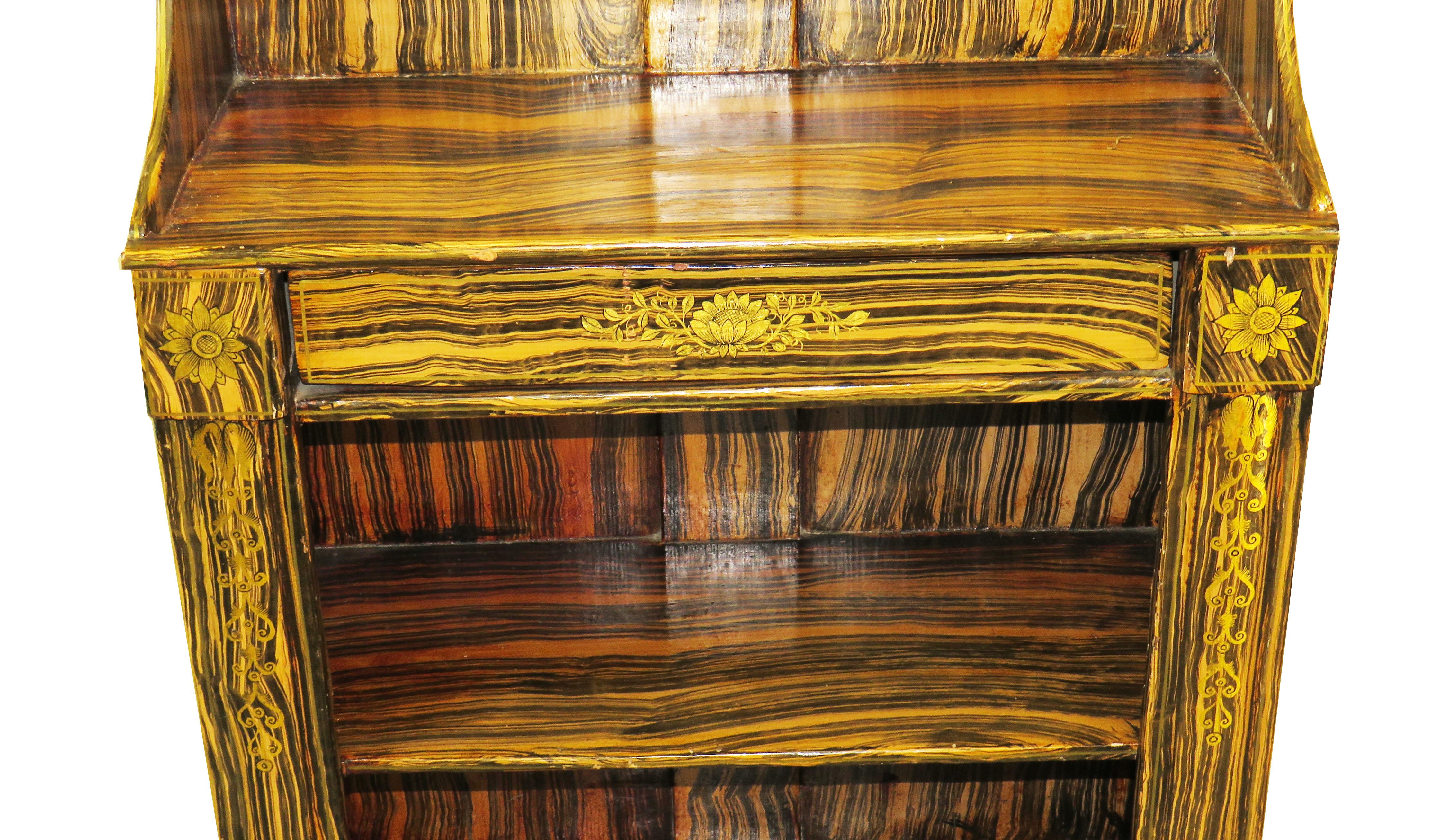 A delightful Regency period simulated coromandel waterfall bookcase of
Diminutive proportion having two shelves to upper tier above one frieze
Drawer and further shelf raised on elegant original turned feet with
Attractive gilded decoration