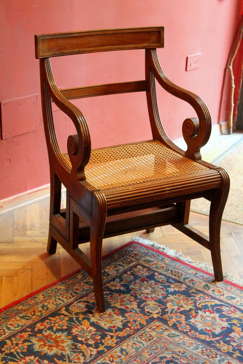 Cane seat and arched back for plenty of comfort, four steps covered with ocher yellow leather inserts turn this stable and sturdy solid 19th century mahogany armchair into a library ladder.
This Regency style metamorphic chair constructed in the