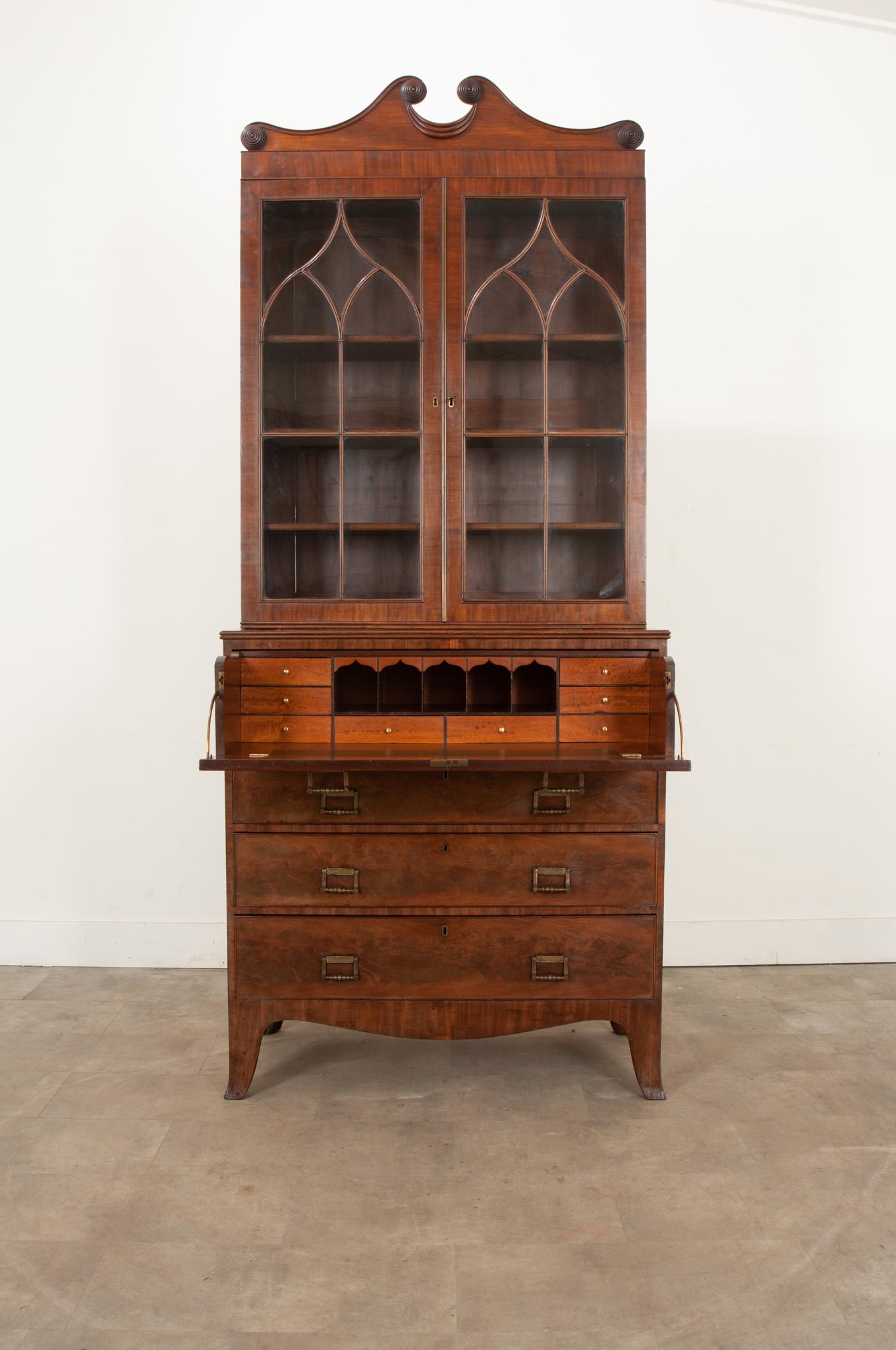 A fine English mahogany secretary, done in the Regency style circa 1830. This outstanding desk has an upper body for storage and display. There are three adjustable finished shelves situated behind the styled doors with original glass. The doors