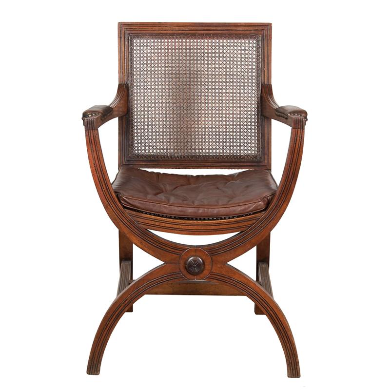 Stylish English 19th Century mahogany Curule chair sitting on fluted x-frame legs centred with a roundel.

Having its original horsehair filled buttoned leather squab cushion.
