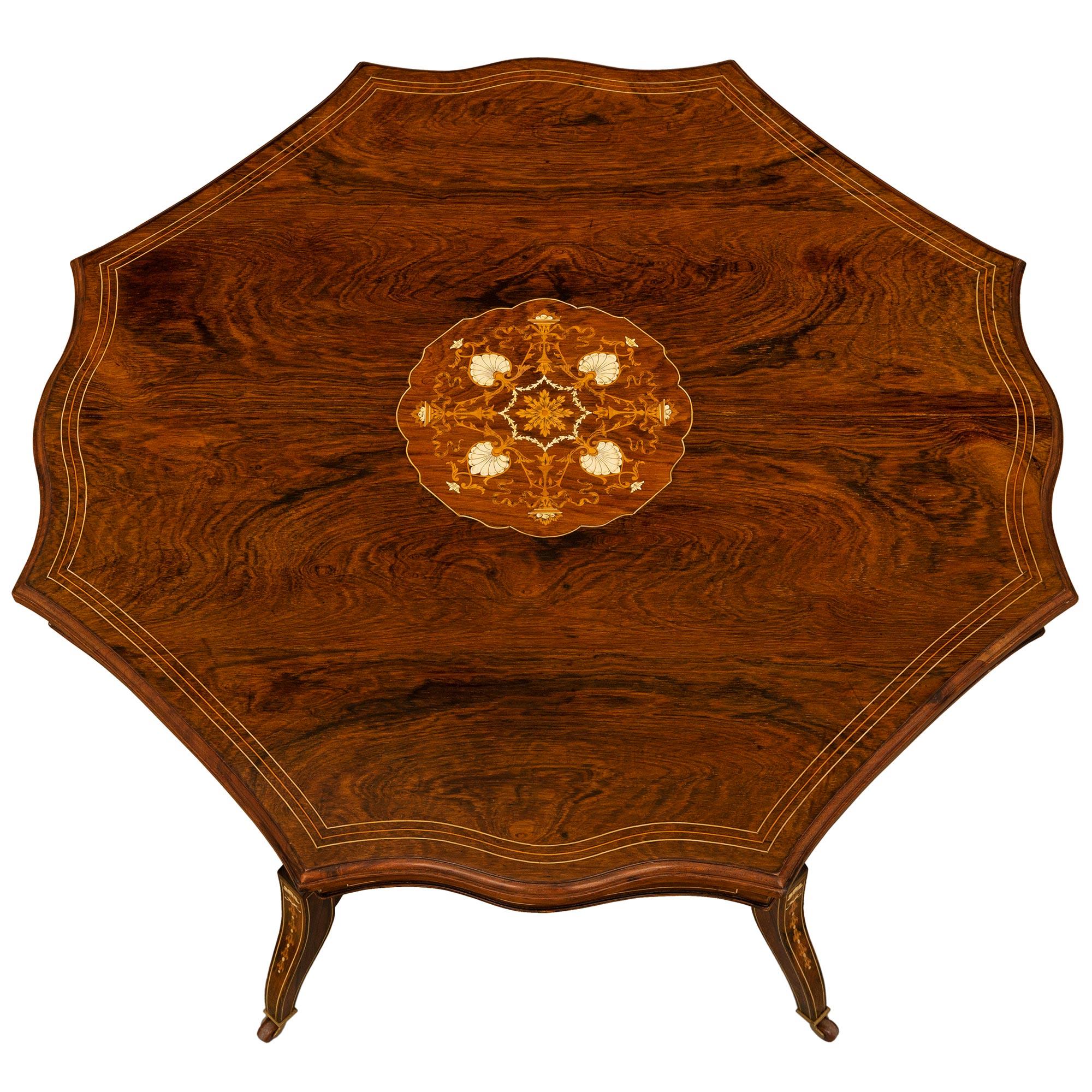 A striking and most unique English 19th century Regency st. rosewood, bone and inlaid center/side table. The table is raised by elegant lightly curved feet with lovely foliate inlaid designs. Each foot is attached by a most decorative stretcher with