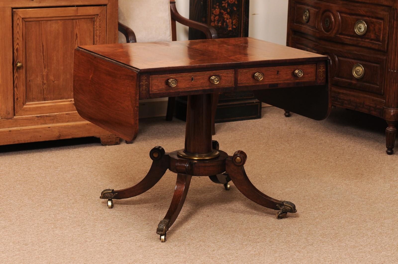 English 19th Century Rosewood Drop Leaf Sofa Table with Brass Inlay/Mounts, Pedestal Base and 4 Splayed Legs Ending in Castor Feet

37″W (closed) X 59″W (open) X 26″D X 29.25″H X 24.25″AH