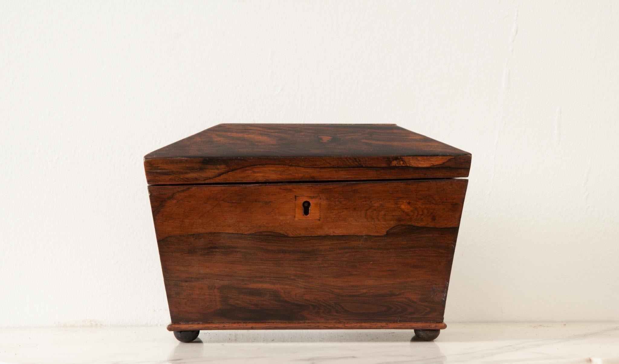 Petite boîte à thé en bois de rose anglaise du 19e siècle. Cette boîte possède un couvercle angulaire qui s'ouvre sur un intérieur aménagé. Il y a deux compartiments avec des couvercles amovibles utilisés autrefois pour conserver les thés en