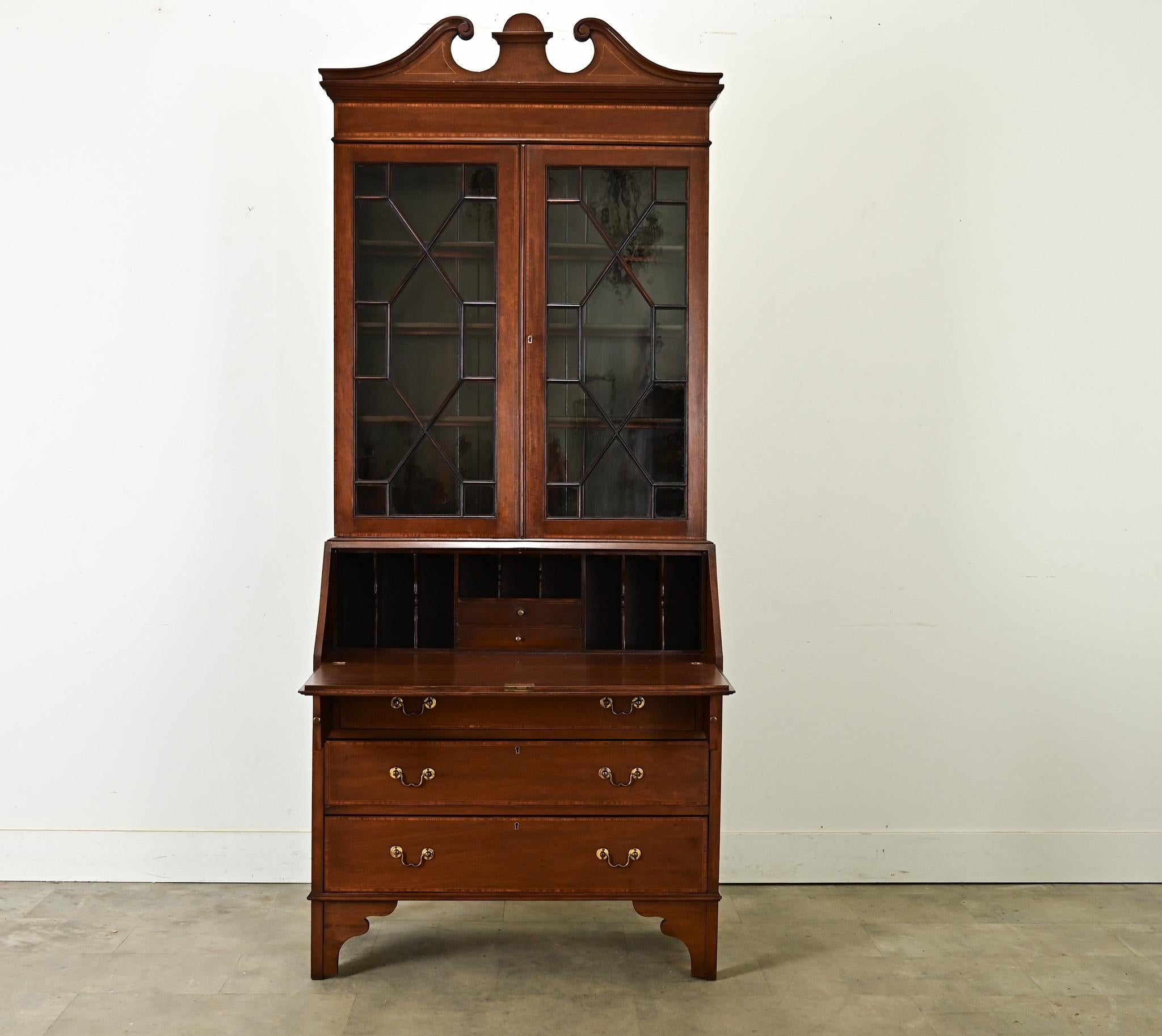 Una snella libreria bureau in mogano con scrivania, realizzata in Inghilterra, circa 1820. Il corpo superiore della segretaria è coronato da un piedistallo spezzato - una classica caratteristica Sheraton - e sovrasta ante in vetro che sembrano