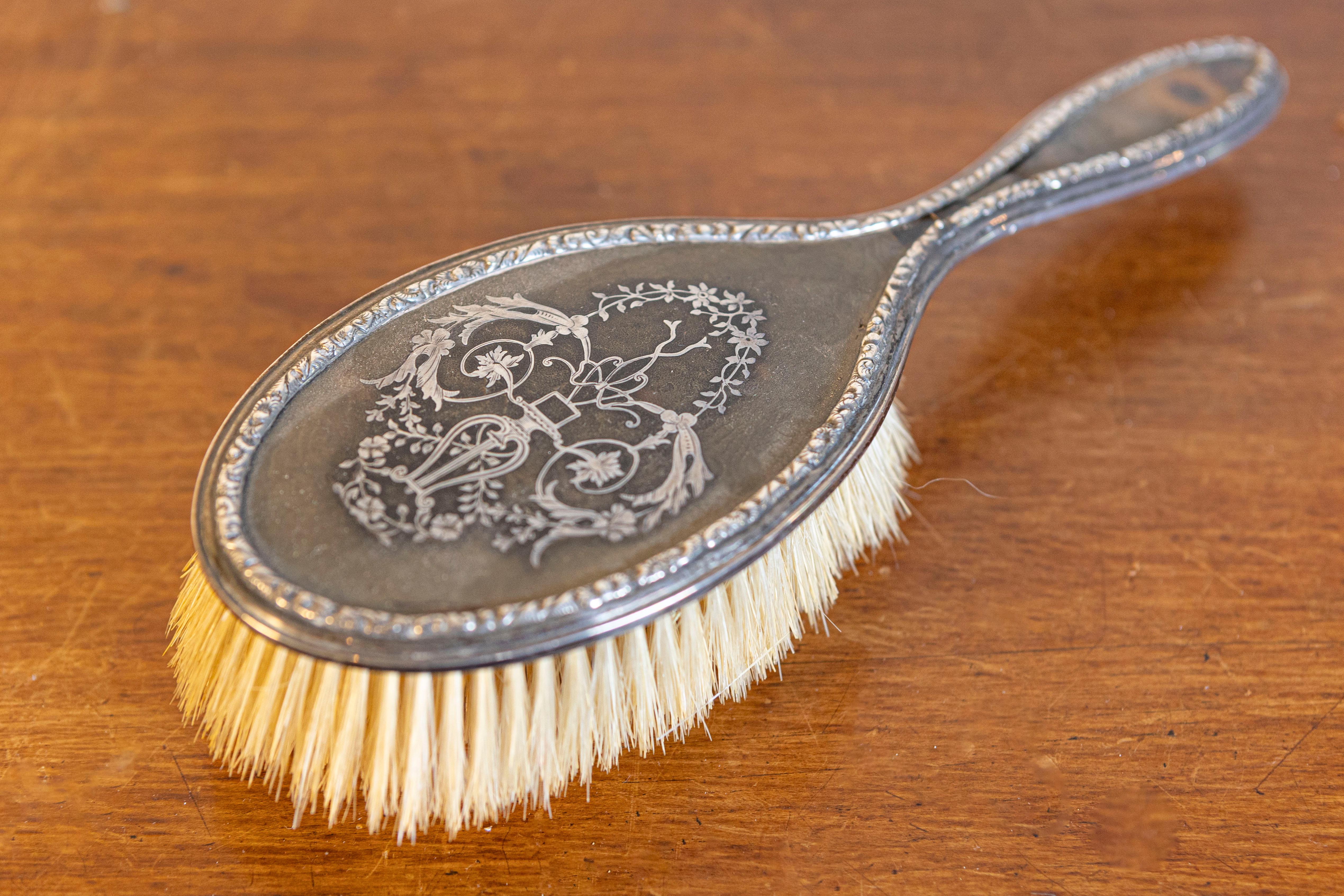 Spazzola da toilette inglese in argento del XIX secolo con decorazioni in piqué d'argento a lira e arabeschi floreali. Nata in Inghilterra nel XIX secolo, questa squisita spazzola da toilette presenta un corpo ovale, delicatamente ornato da una