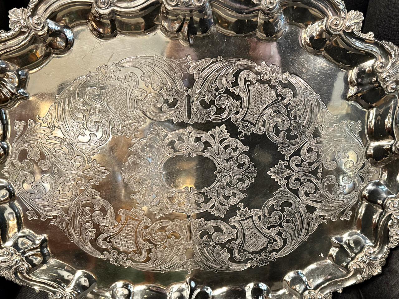 This is a very good example of a traditional English Silver Plate Tea Tray that dates to the late 19th century. The tray is elaborately detailed and finely cast  in the Rococo style, silver plated and hand chased. The applied shell and Rococo