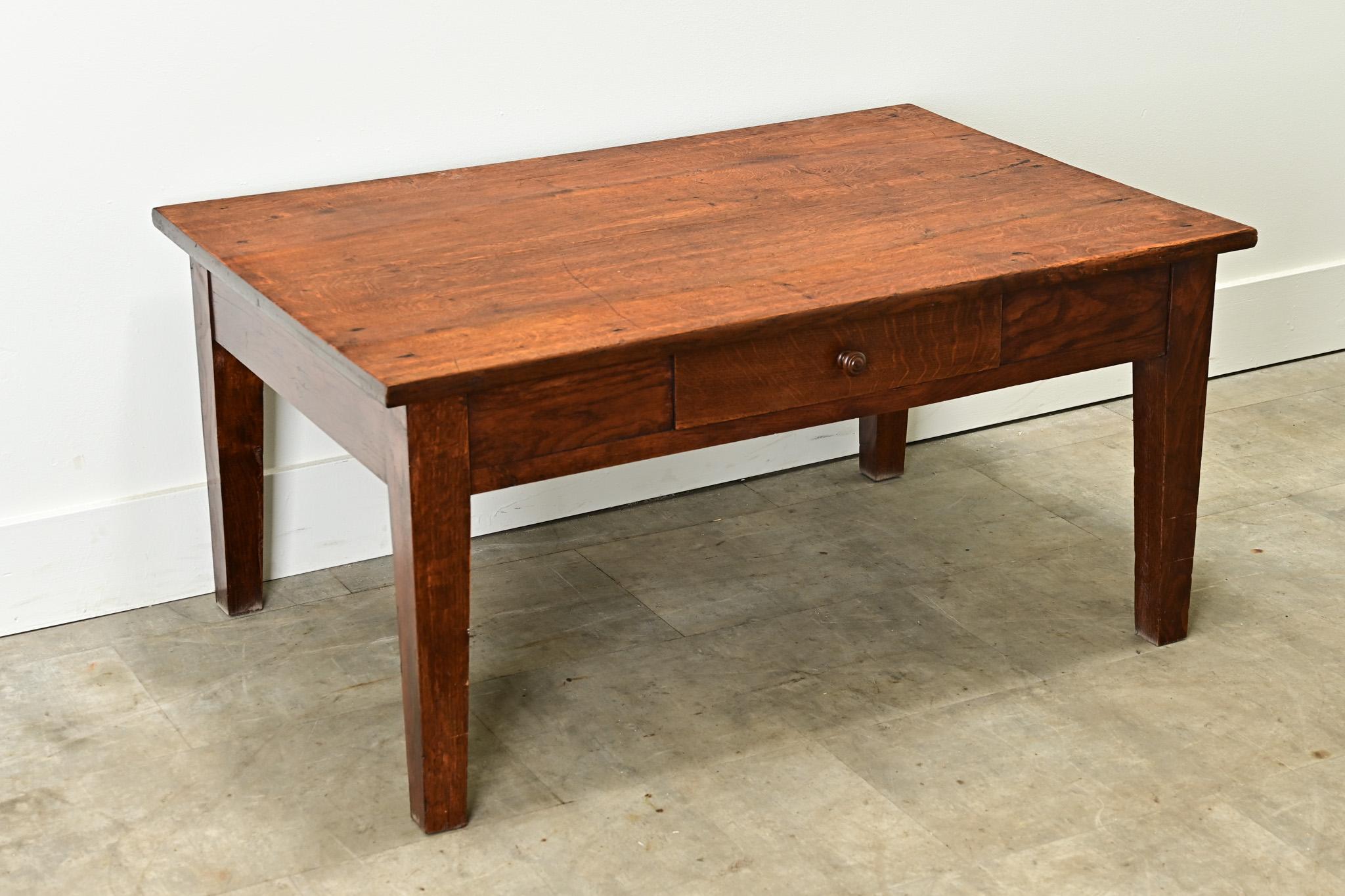An English solid oak low table with handsome grain patterns would make the perfect coffee table. The plank top sits over the table base with a single drawer and tapered legs. Cleaned and polished with a paste wax, this antique pedestal table is
