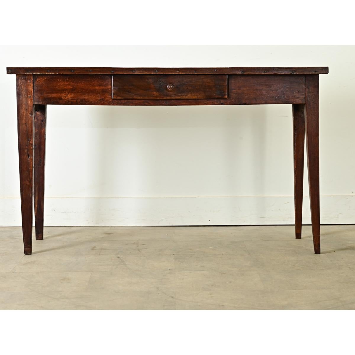 This handsome English oak server, circa 1850, features a rectangular top in ruddy brown patina showing textural dimension in the wood grain. The narrow surface is framed by an applied trim around the edge, dotted with tiny nail heads and sits over a