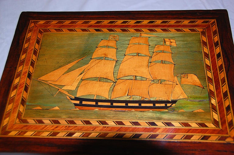 English rosewood 19th century Trinity House dressing box with perspective cube inlay to three sides and a British three masted square rigged schooner inlaid to the top; she is sailing on a white capped sea. Various woods were used for the inlays