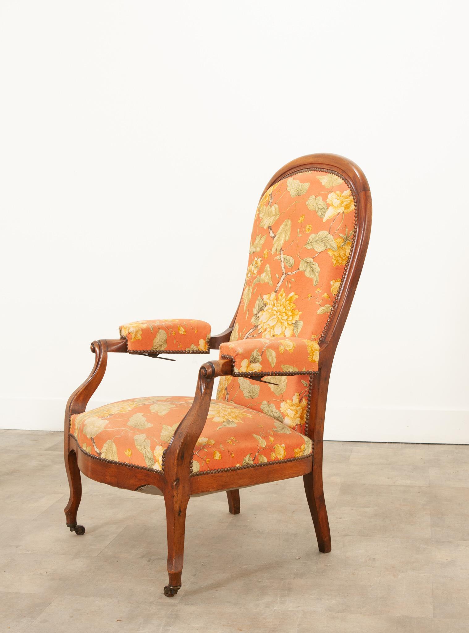 A rare 19th century English mahogany reclining high back arm chair with floral upholstery and under arm metal reclining mechanism. A lovely Victorian reclining armchair that is fashionable as well as exceptionally comfortable. Of elegant