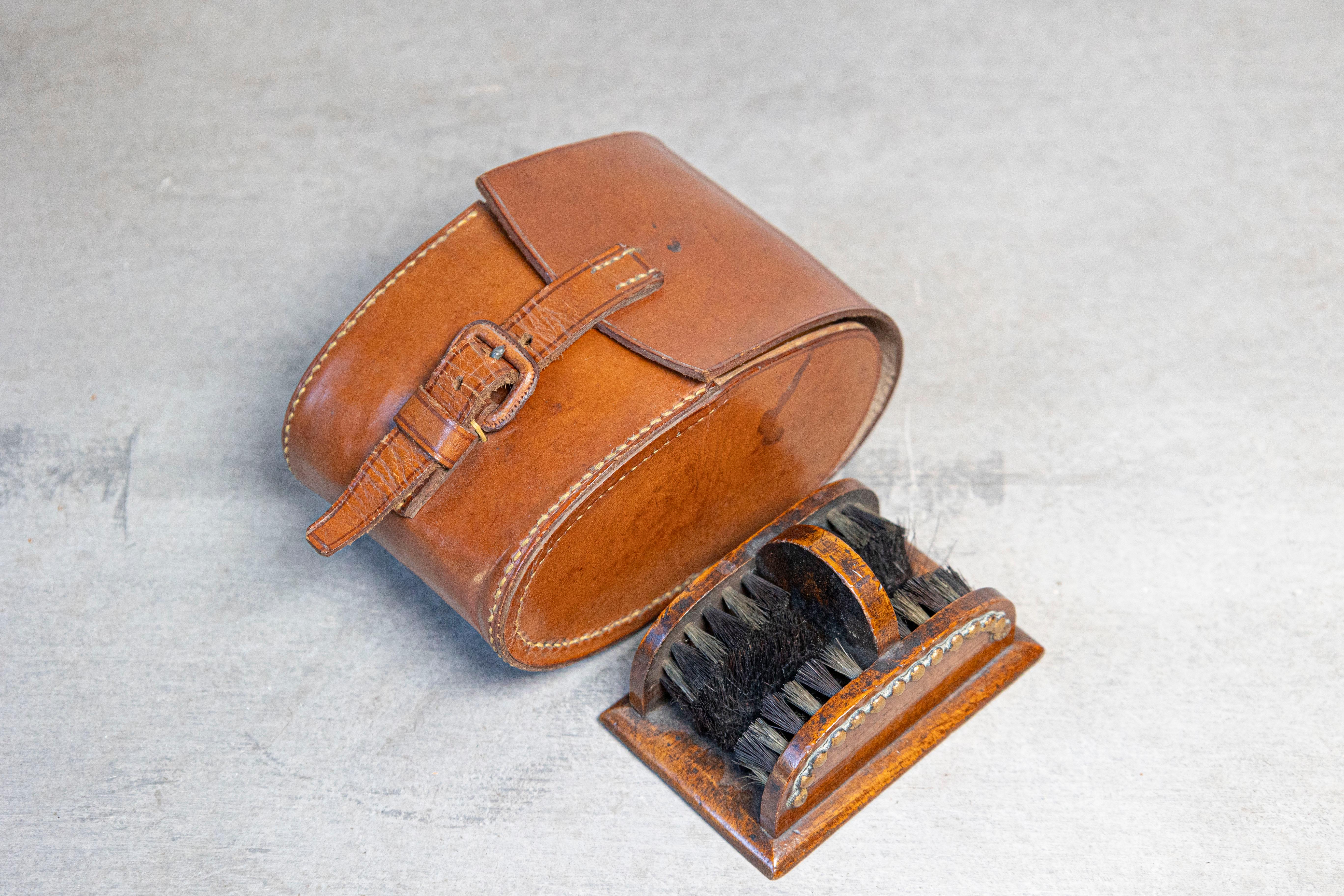 An antique English Victorian period shoe care set from the 19th century, with four brushes and original leather case. Created in England during the reign of Queen Victoria, this shoe care set features an oval leather case measuring 5.25