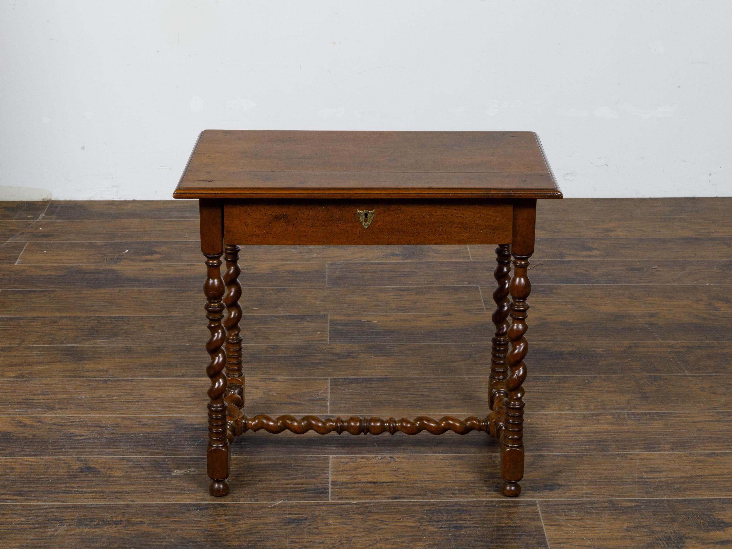 An English barley twist walnut side table from the 19th century with single drawer. This elegant 19th-century English walnut table showcases the timeless charm of barley twist craftsmanship, making it a versatile piece that complements both