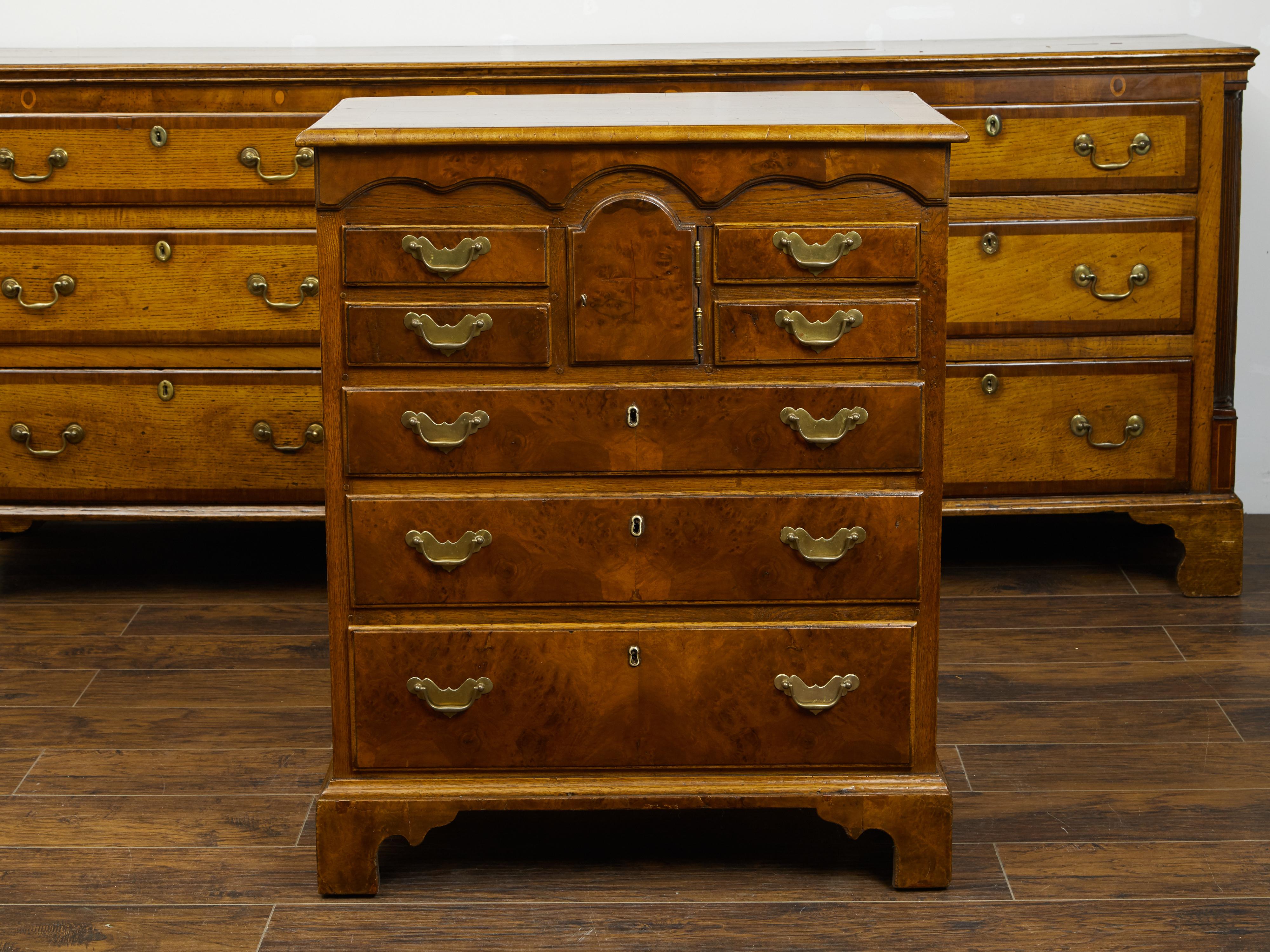 An English walnut commode from the 19th century, with graduating drawers and petite door. Created in England during the 19th century, this walnut commode features a rectangular top with quarter veneer, sitting above a perfectly organized façade.