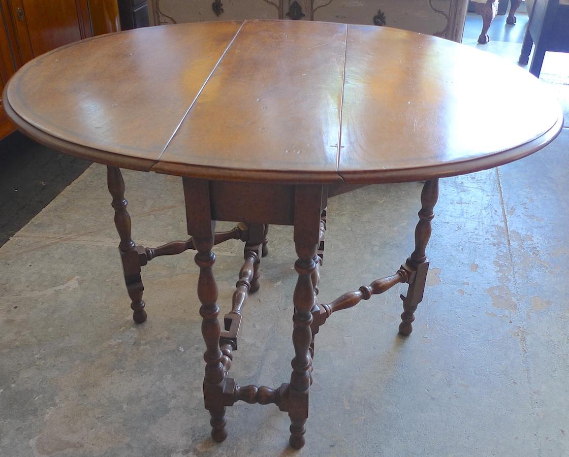 English 19th century walnut gate-leg, drop-leaf oval table with turned legs.