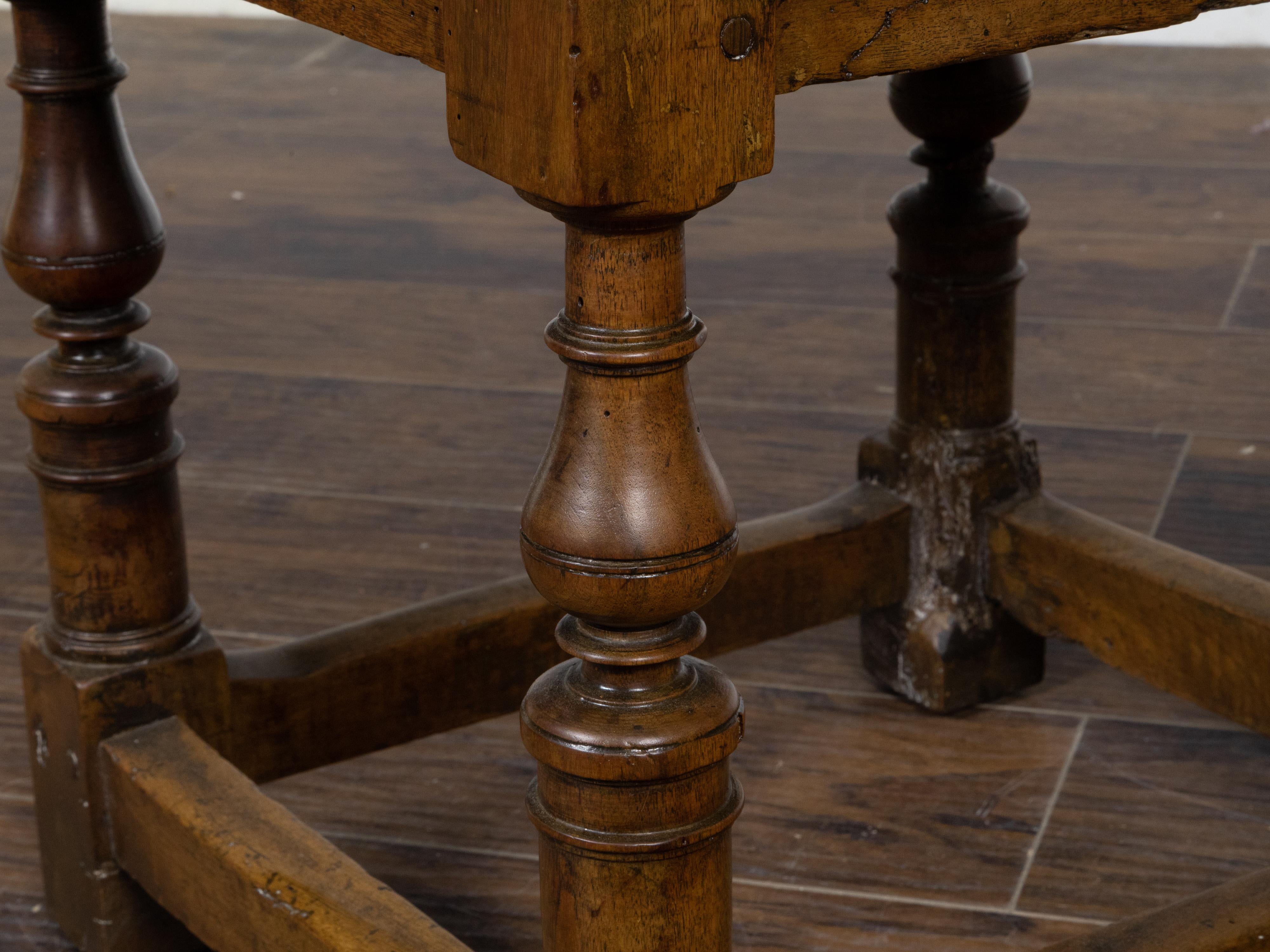 An English walnut side table from the 19th century with single drawer, turned baluster legs, plain side stretchers and nice patina. A blend of ageless charm and practicality, this 19th-century English walnut side table exudes an air of refined