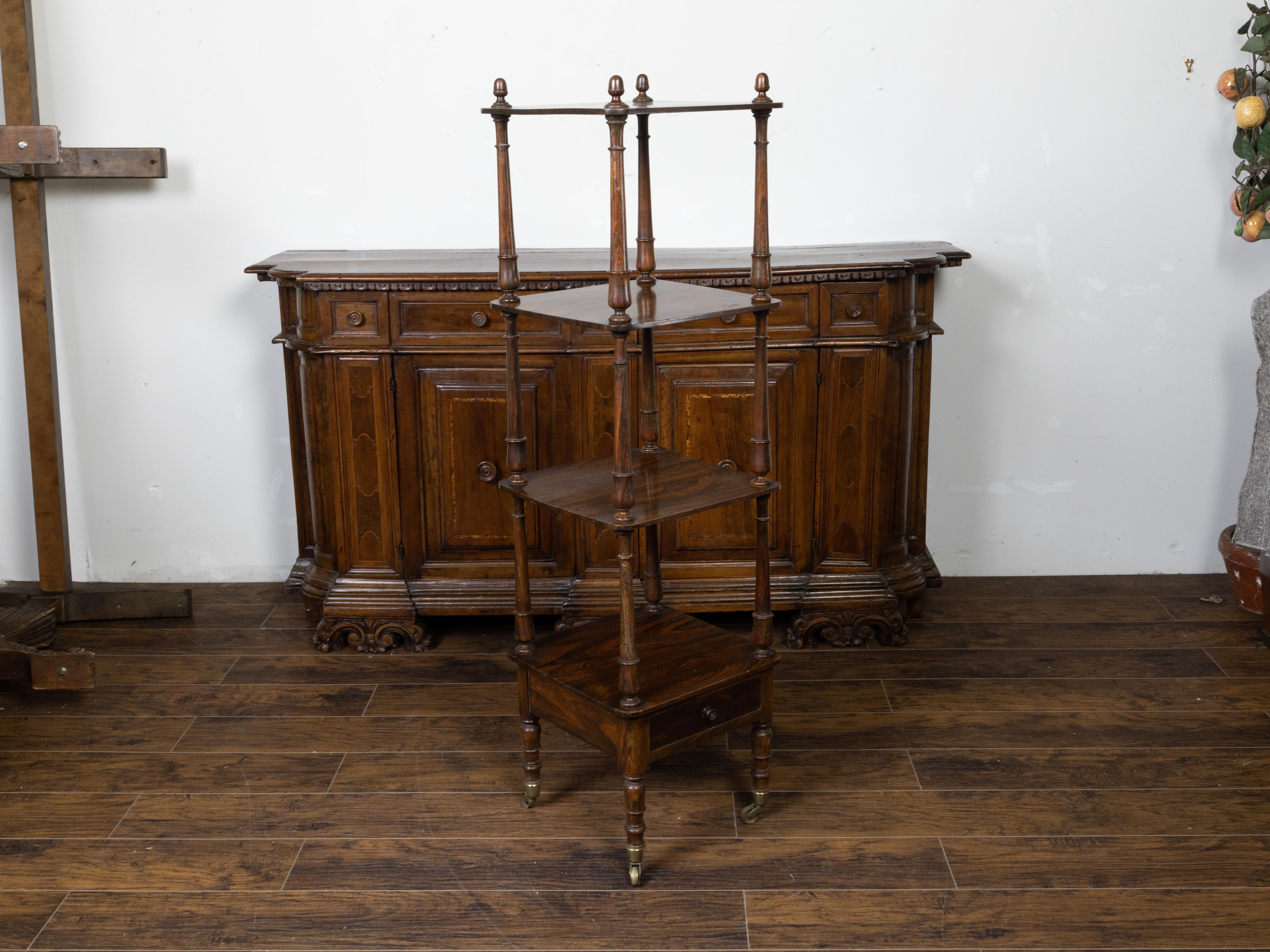 An English wooden trolley from the 19th century, with three shelves, low drawer and turned supports. Created in England during the 19th century, this tall trolley features three square-shaped shelves secured within turned supports topped with acorn