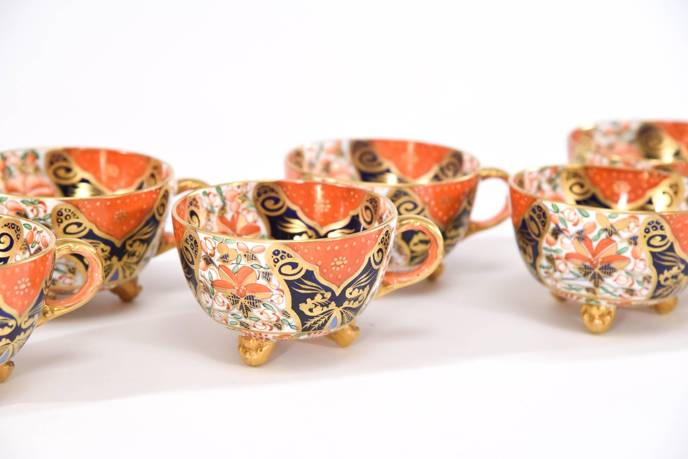An amazing hand painted example of the influence of the Japonesque influence on English wares ca. 1890's. This is a complete set of 8 footed cups and saucers and 8 matching dessert plates accompanied by a creamer and sugar/waste bowl set. The