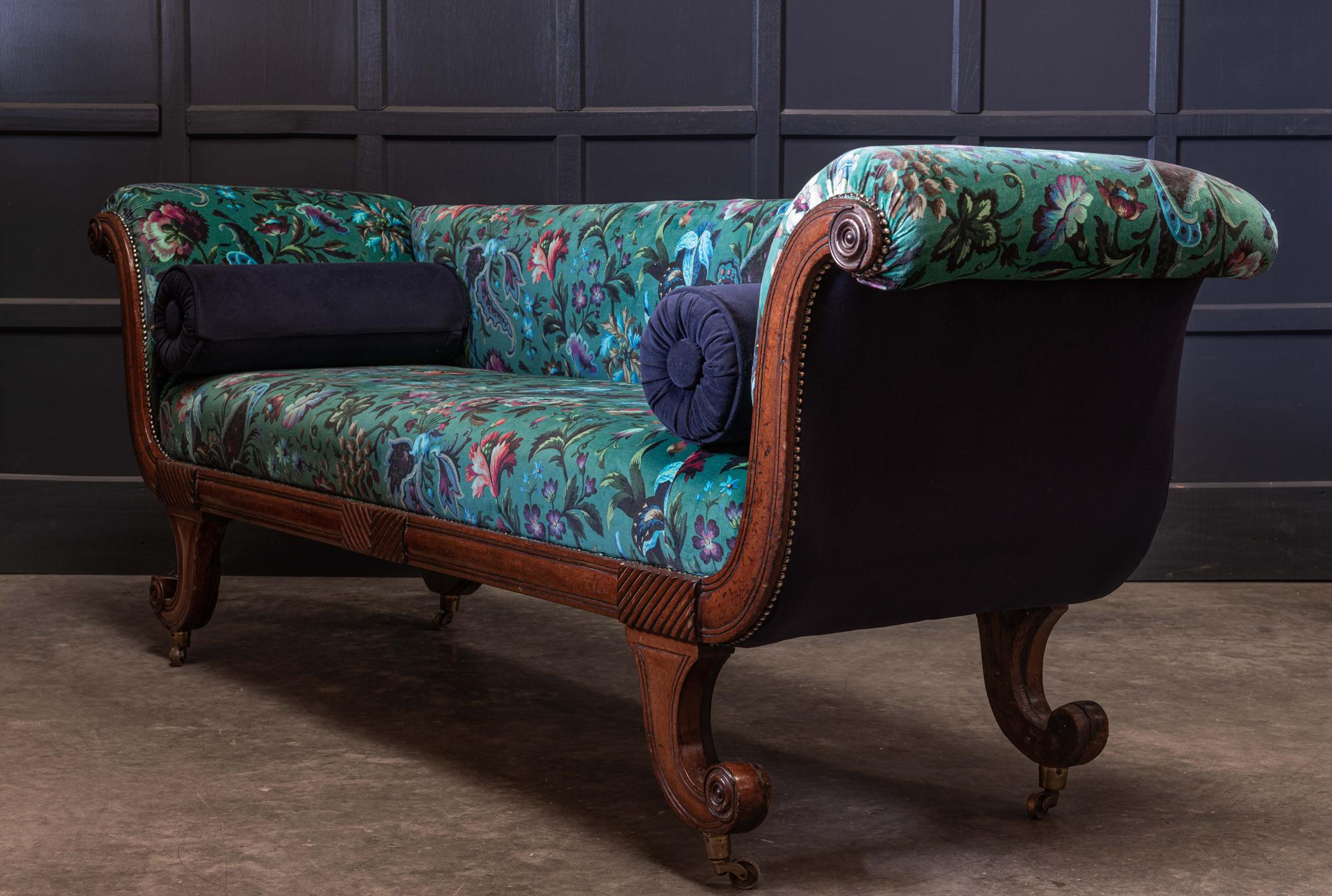 English 19th century Regency mahogany scroll end sofa, reupholstered.
circa 1820.

Regency mahogany scroll end sofa. Sat on original solid brass castors and reupholstered in Velvet ‘Florika’ Petrol Fabric with two matching buttoned bolster