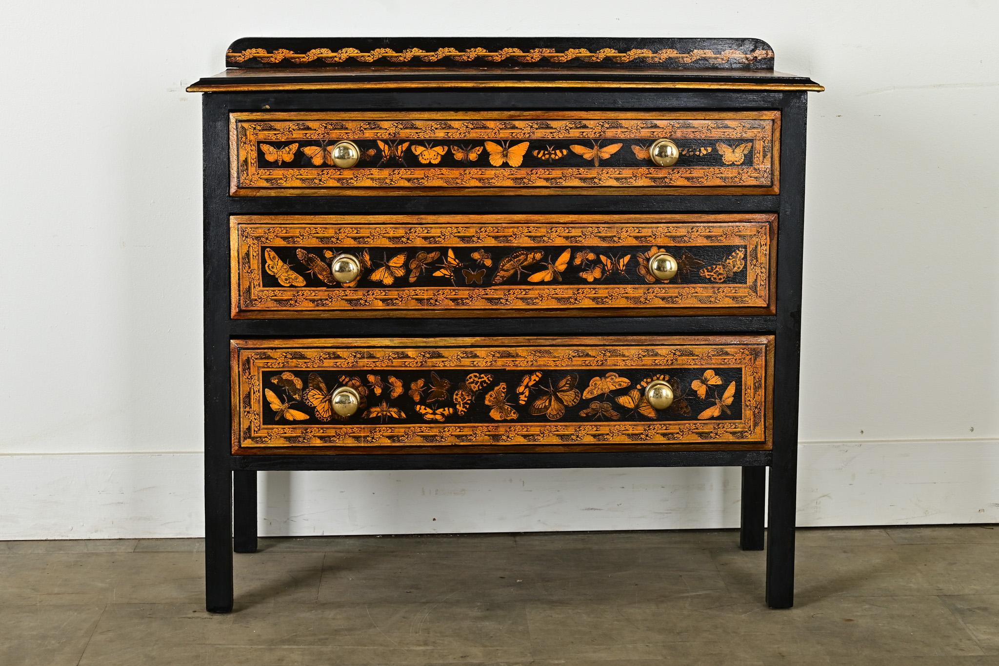 Recently updated with ebonized (painted) and decoupage, this early 1900s pine chest from England would be a charming addition to your home. Solid pine makes for sturdy construction of the case with three drawers, opened by shiny brass knobs. The