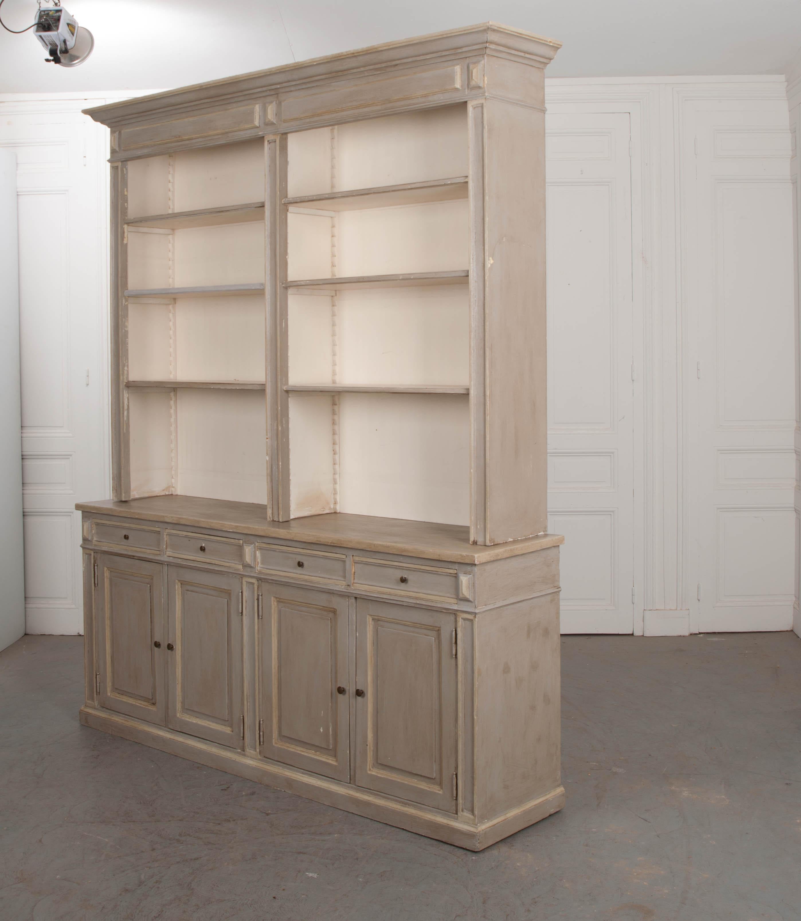 This beautiful reproduction Georgian-style bookcase is painted pale-grey with pale-green highlights and a cream interior including the drawers. The upper bookcase is divided into two parts and outfitted with three adjustable shelves resting on a