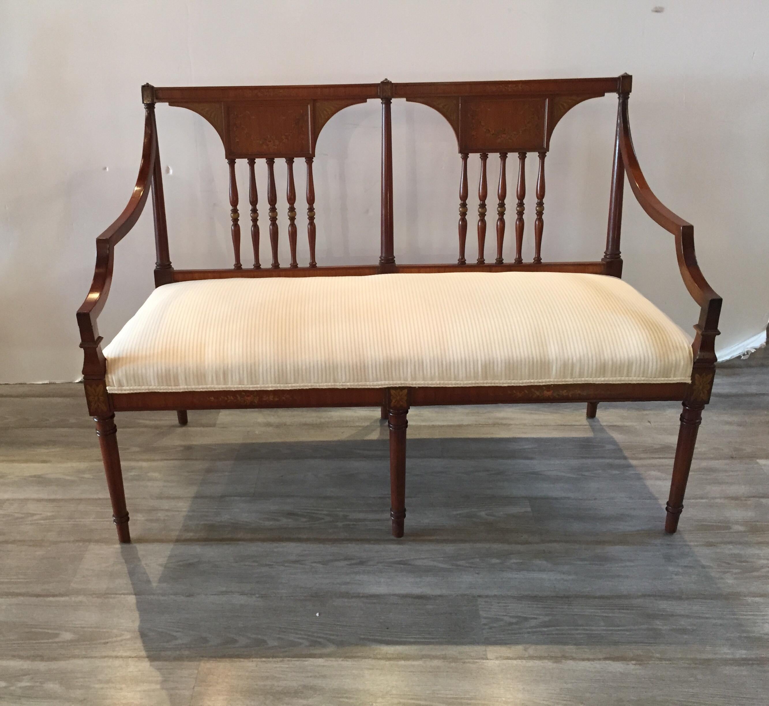 Elegant English Adam style satinwood hand painted settee with neutral oyster micro stripped upholstered seat. The simple lines with small carved details at the corners with hand painted details on the back and along the apron.