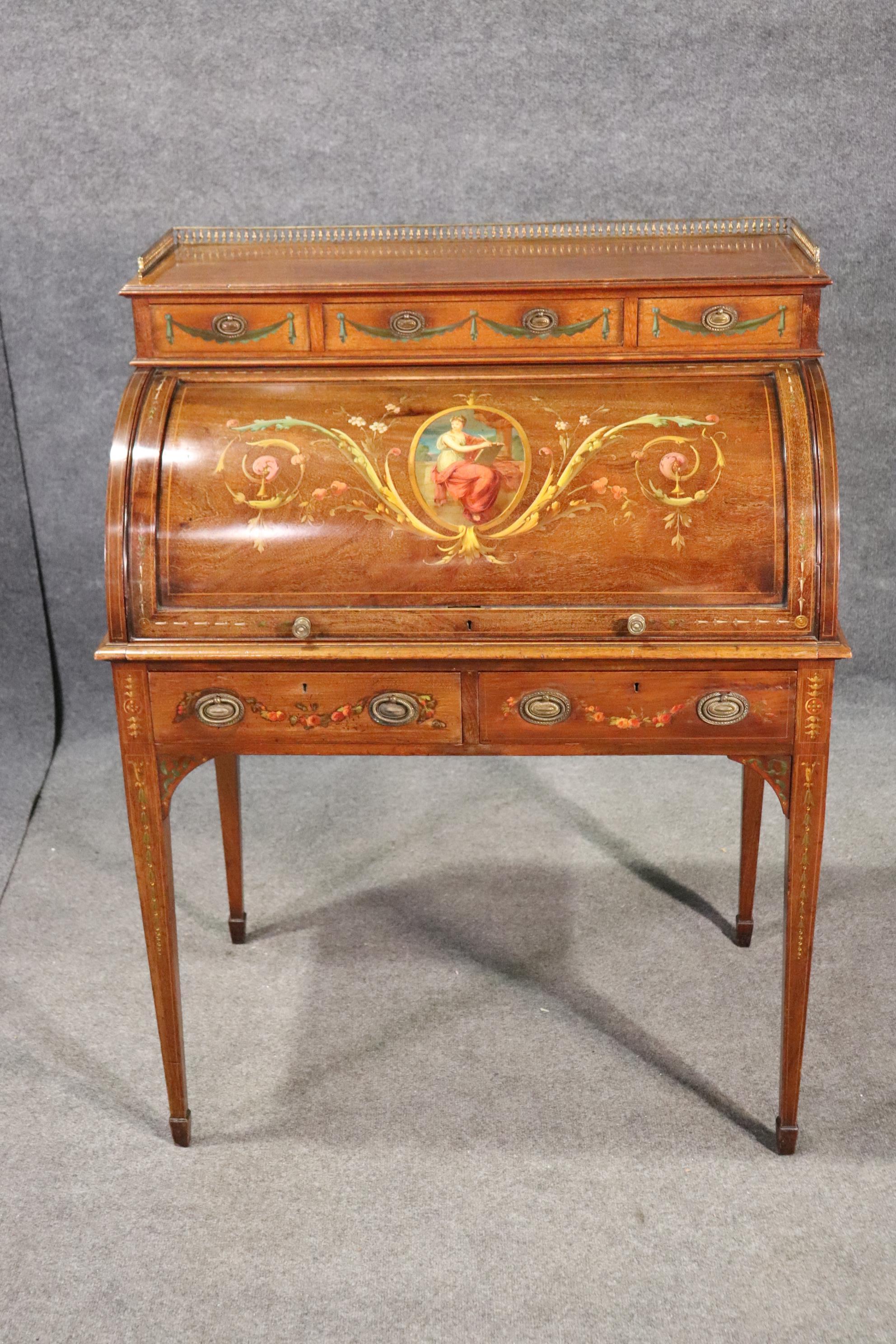 This exceptional paint decorated cylinder desk is in good original antique condition and features the most beautiful painting, and the leather desk surface is embossed and gold tooled. The desk is made of superb mahogany and is one of the most