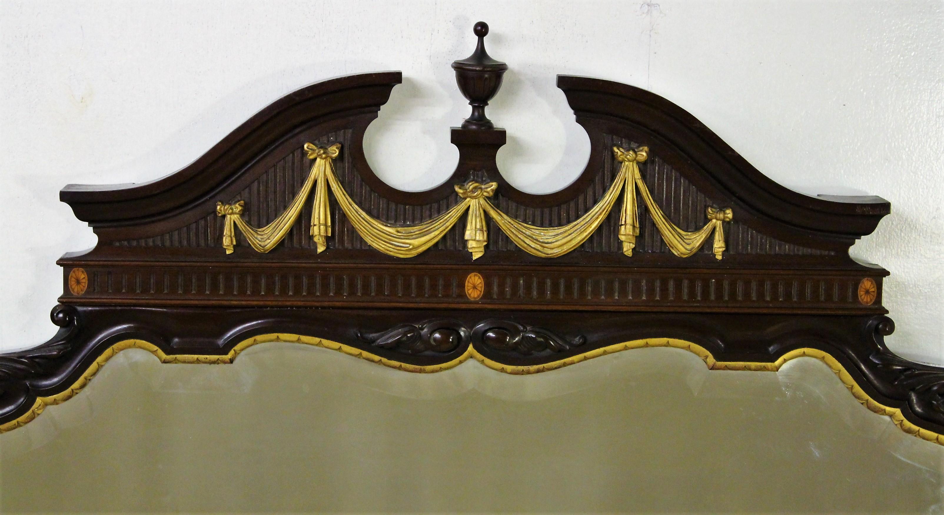 An impressive mahogany wall mirror, or over-mantel (fireplace), from the Edwardian period in the style of Robert Adam. Of generous proportions and very well made in solid mahogany with carved scrolling decorations, swags, inlaid paterae and