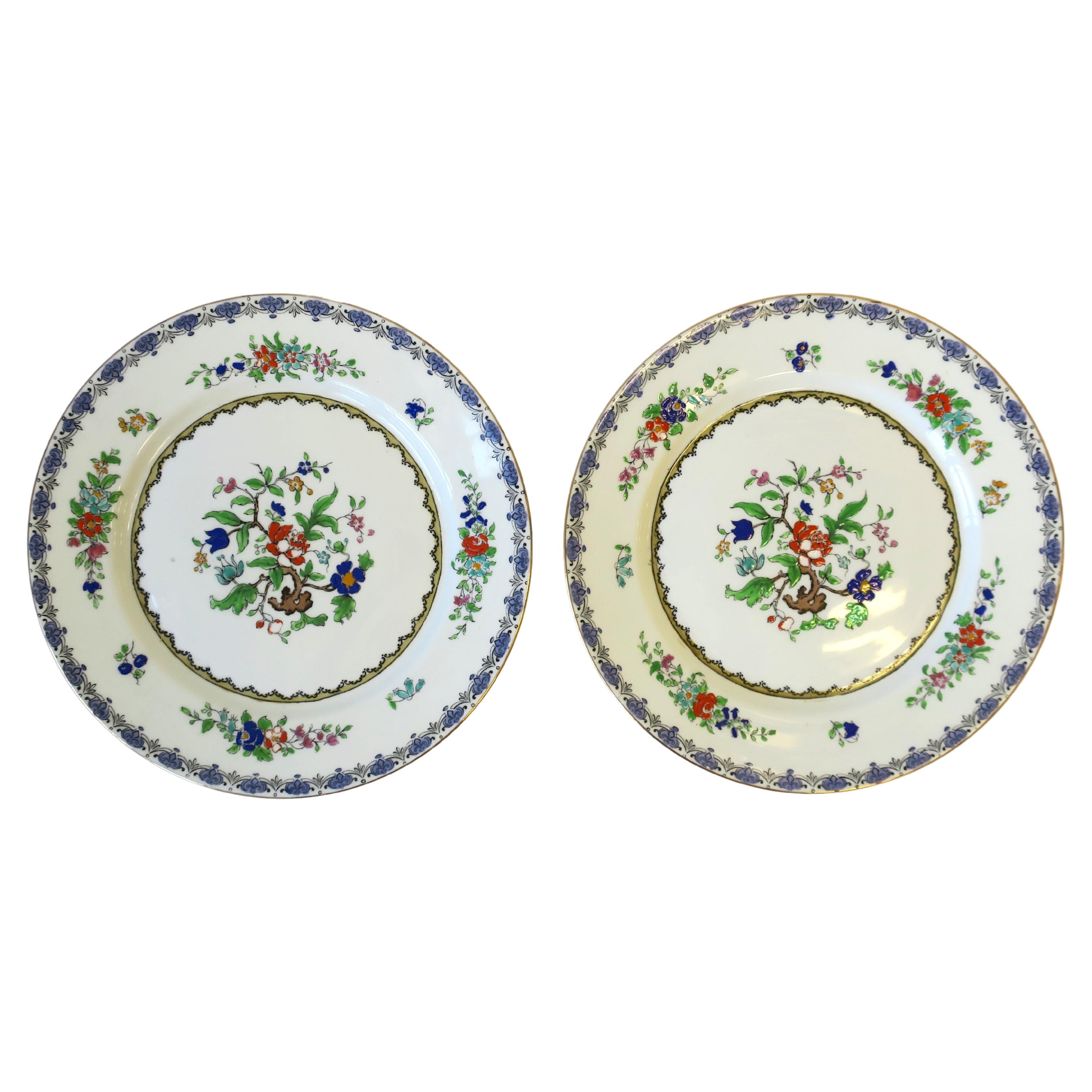 A pair of English fine bone china porcelain plates with a beautiful floral botanical center design, by Adderley Ware, circa early-20th century, England. Plates have a beautiful, raised frieze/relief of flowers and leaves at center and around plates