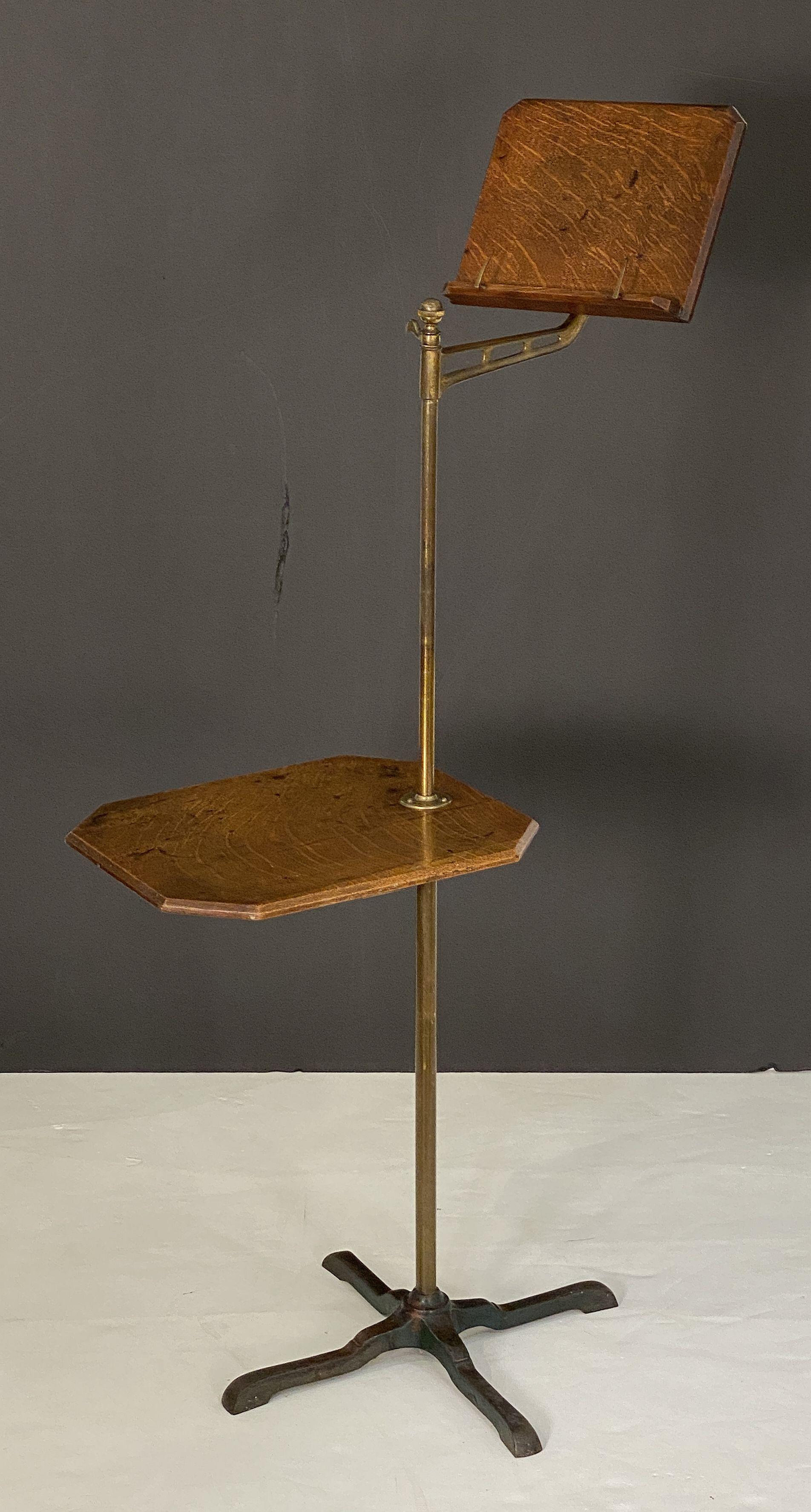 A handsome English adjustable book lectern or reading stand - the book rest of oak mounted to a stand of brass and affixed to a table top of oak with a brass column support with four-legged iron base.

Each part of the stand is adjustable - the