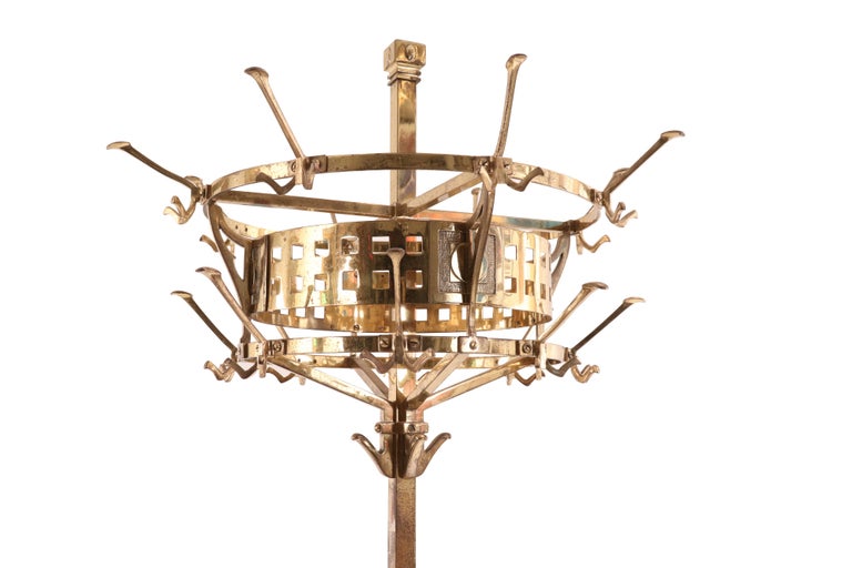 English Aesthetic Movement brass hat rack with circular top, three sets of hooks, and space for umbrellas in the base.
   