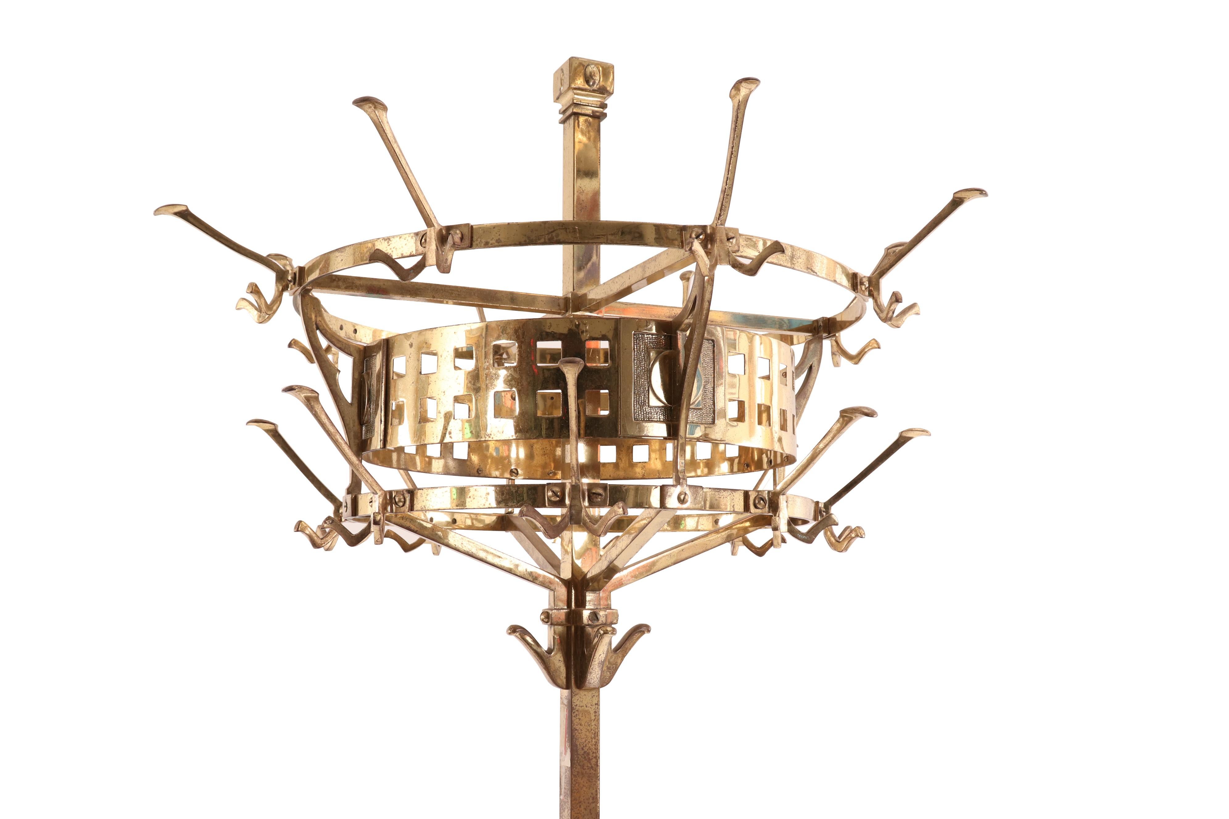 English Aesthetic Movement brass hat rack with circular top, three sets of hooks, and space for umbrellas in the base.