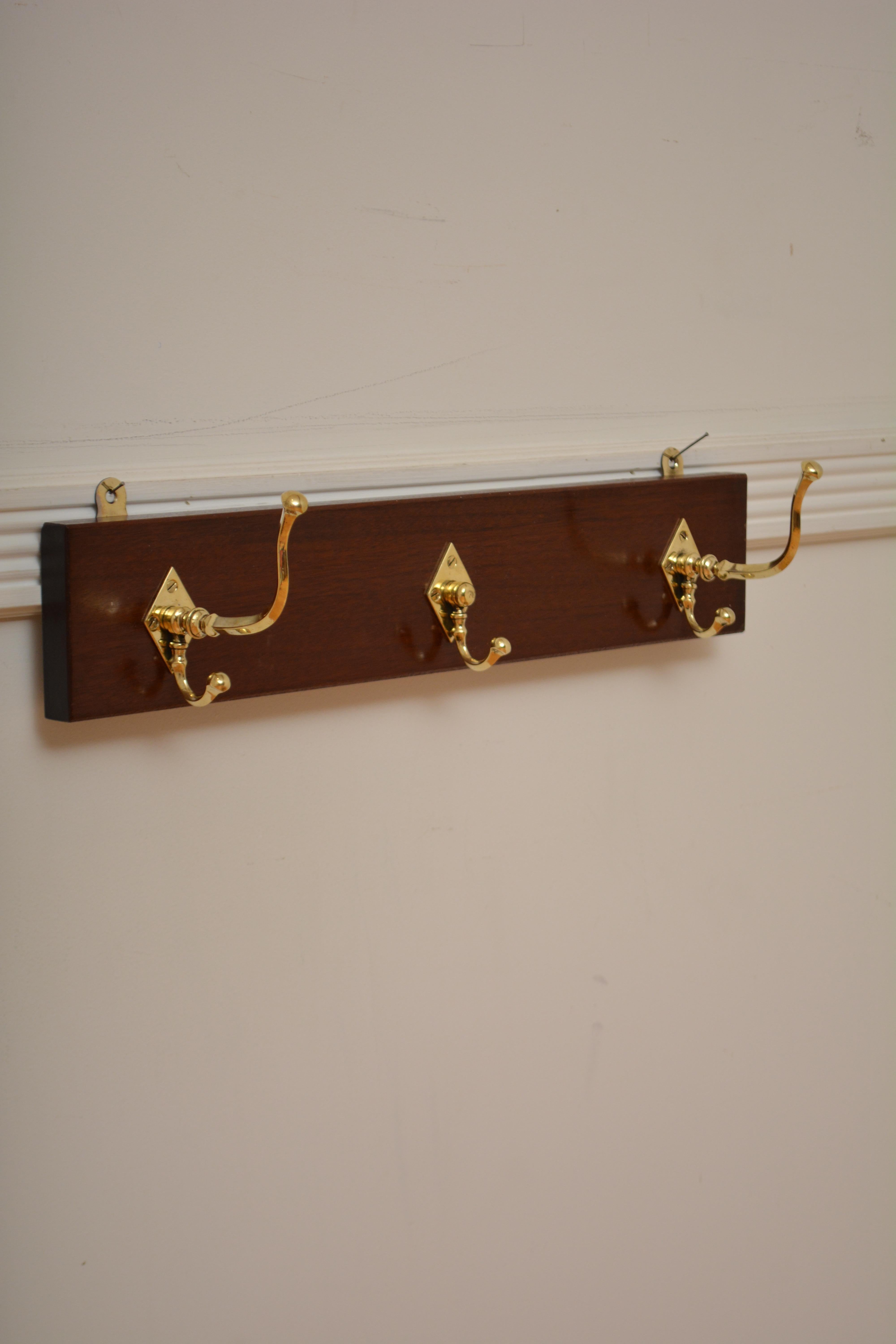 P0308 Attractive set of three Victorian brass coat and hat hooks on solid mahogany backing. Cleaned, polished and fitted with wall fittings this antique coat rack is in home ready condition. c1880
H4.5