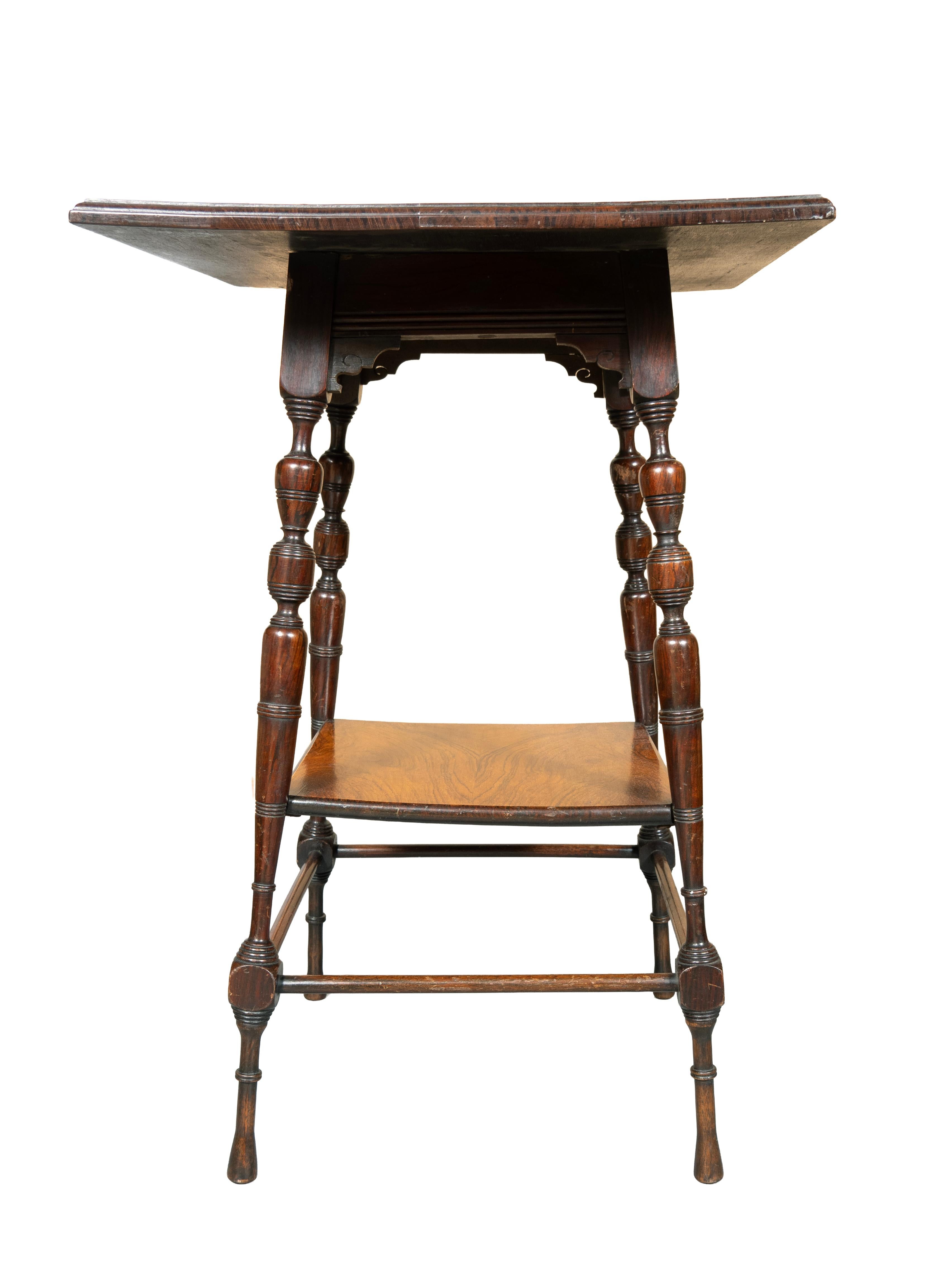 Le plateau carré est orné d'une bande de bois satiné incrusté et d'un bord mouluré. Les pieds sont tournés et rejoignent une étagère inférieure, les brancards sont tournés et les pieds sont tournés et fuselés. Cachet de la couronne sous la base.