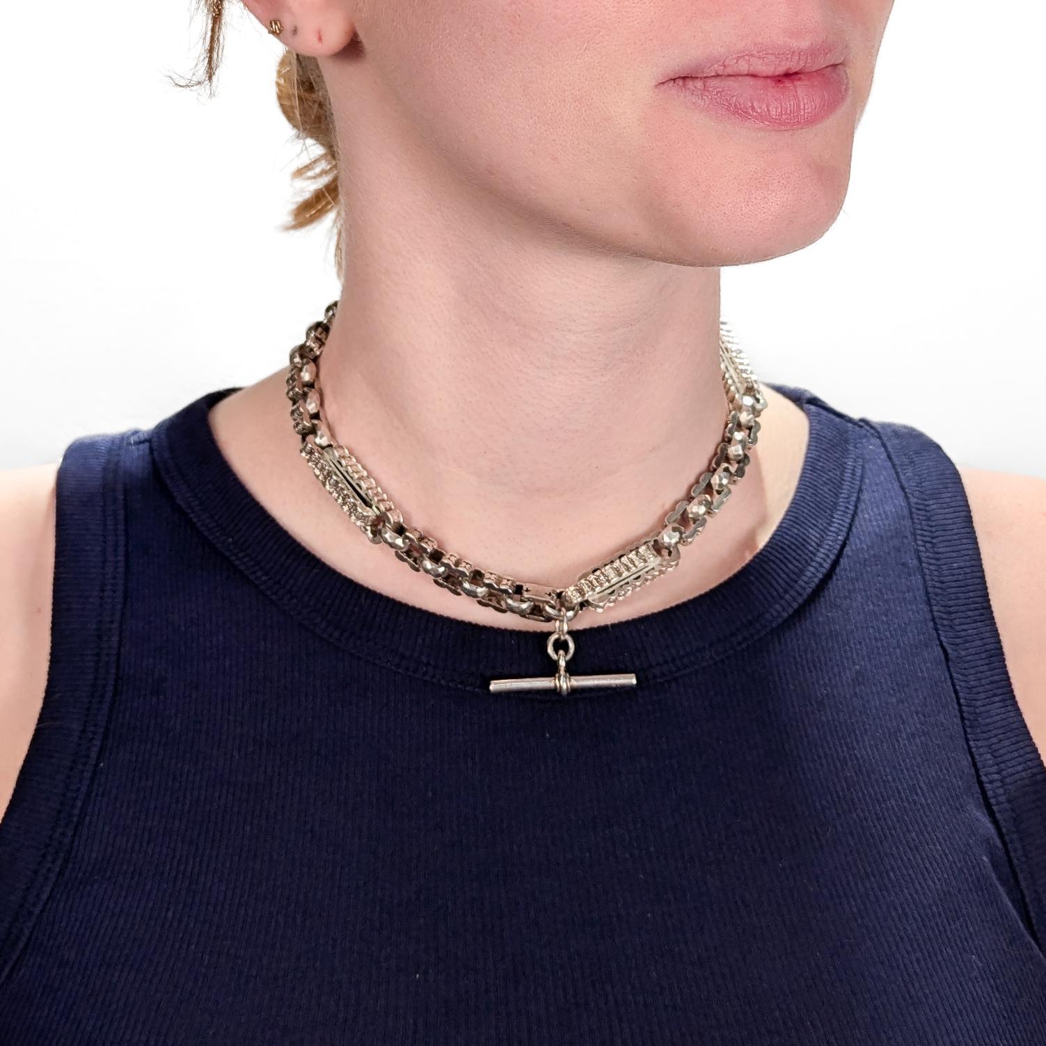 Eine schöne antike Double Albert Uhrenkette.

Aus Sterlingsilber.

Mit geformter Buchkette und ausgefallenen durchbrochenen Gliedern.

Mit einem T-Bar in der Mitte und Dog Clips Terminals.

Tragbar als Halsband oder Halsreif.

Mit englischen Punzen