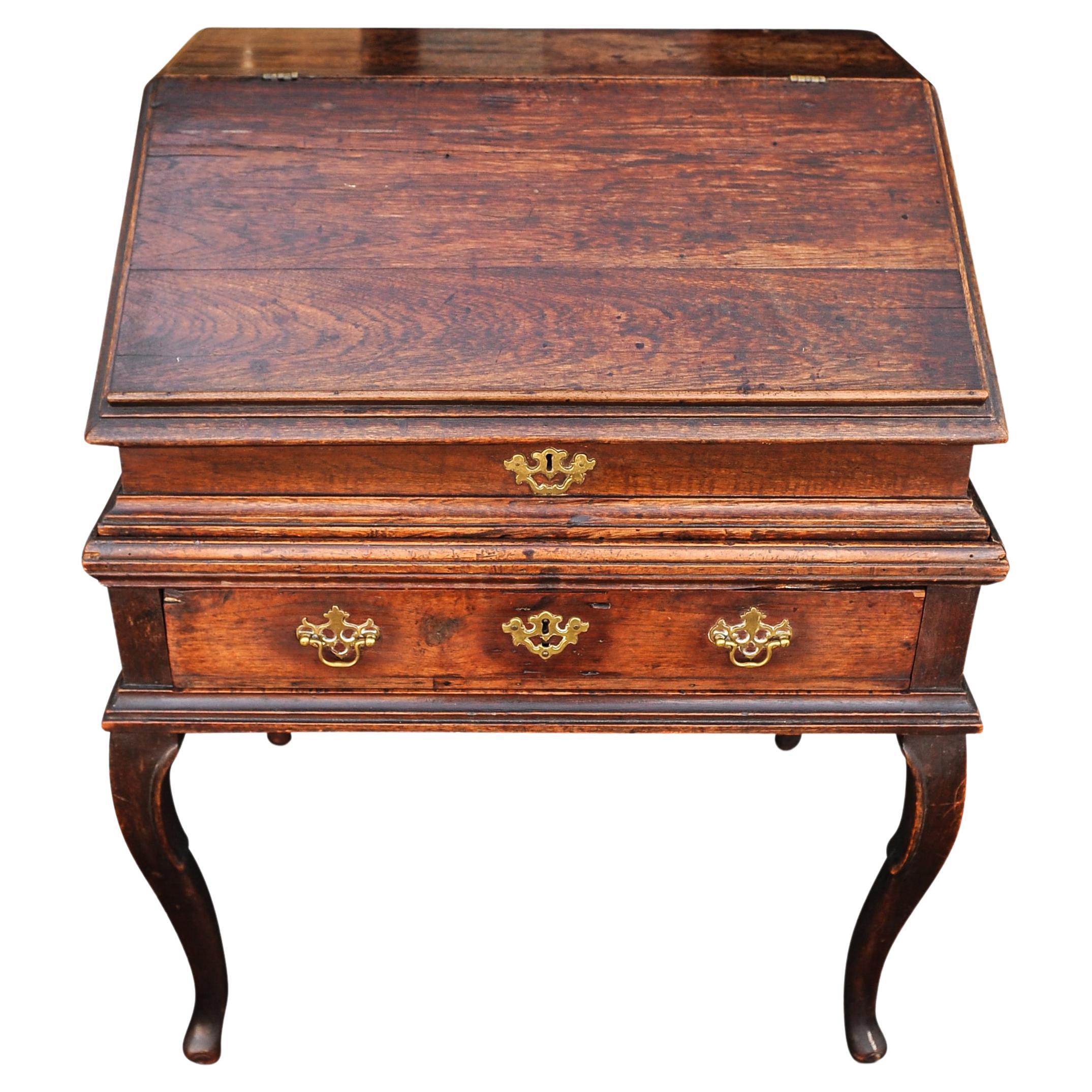 Bureau géorgien du XVIIIe siècle sur Stand. Le couvercle rabattable révèle un intérieur aménagé avec des tiroirs et des compartiments à casiers, dotés de poignées et de finitions en laiton d'origine, datant des années 1700.

La partie supérieure