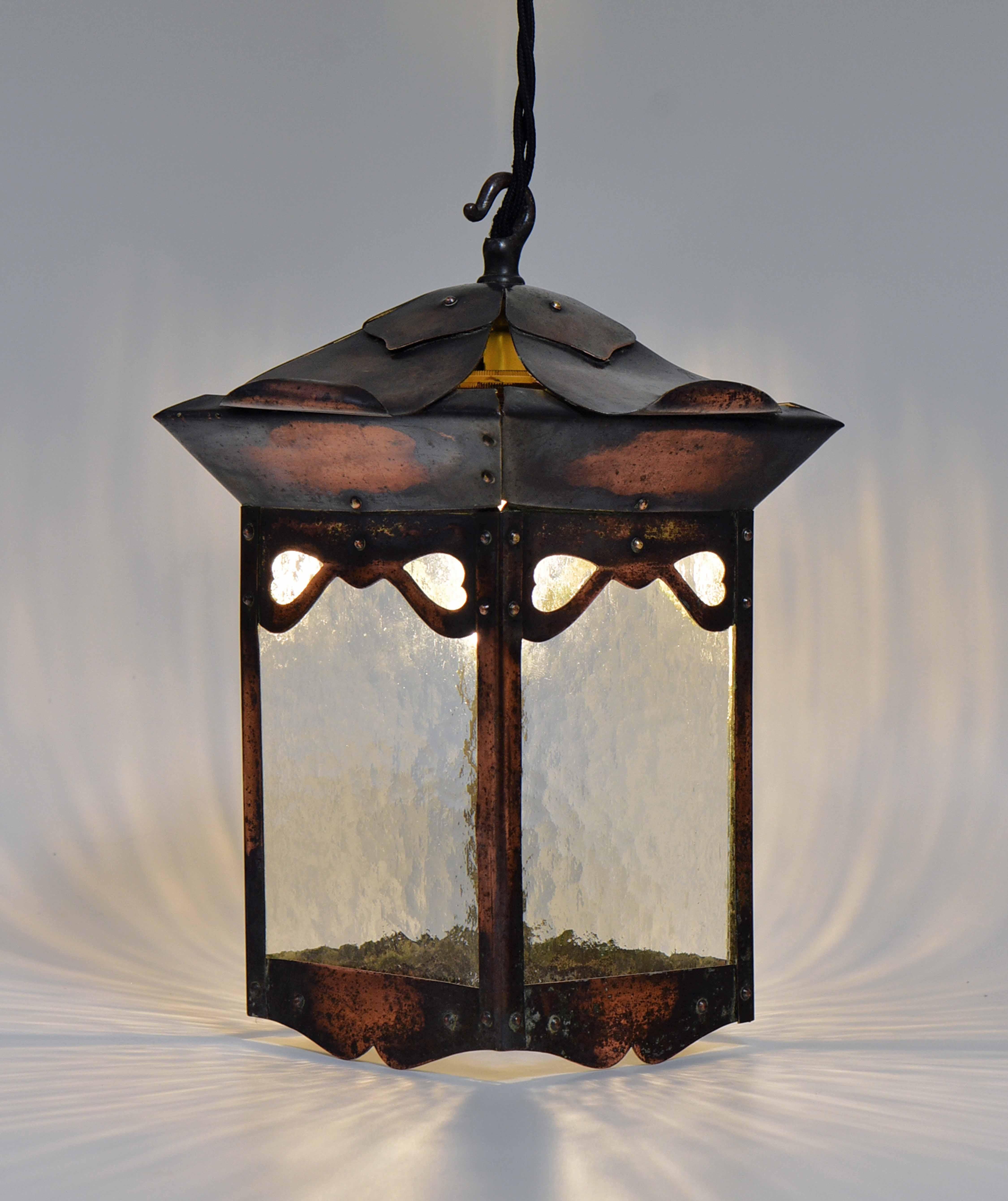 An attractive Arts and Crafts copperised, pressed-metal hall lantern with heart shaped design. Circa 1900.

Free delivery to the UK via a selected parcel company.

The lantern has been re-wired by a competent electrician, with a British plug. It