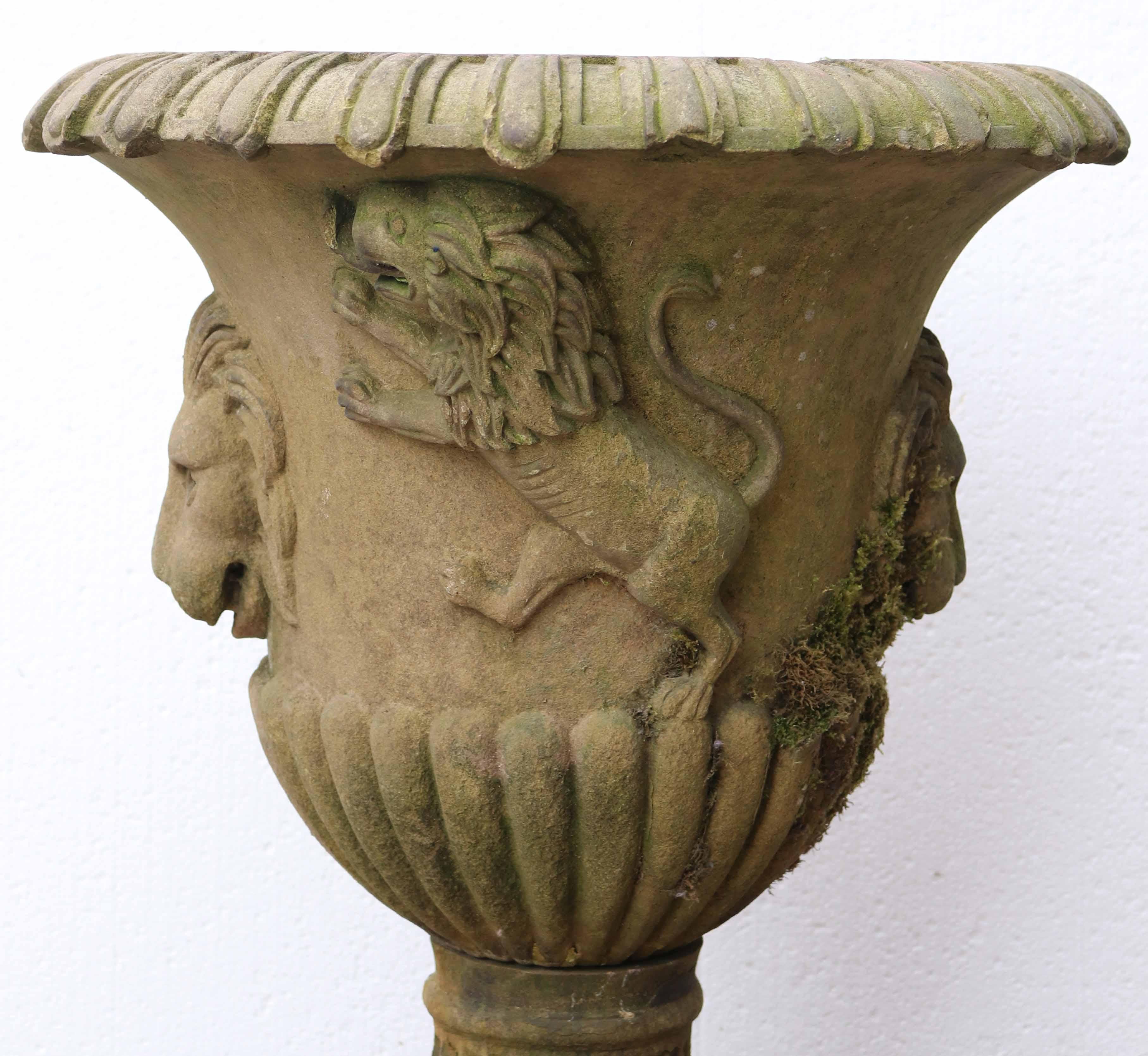 An early 19th century antique English carved Yorkstone urn, hand-carved with rampant lions, lion masks and gadrooning on a fluted socle base. This impressive 200-year-old garden urn dates from the Georgian era, the durable sandstone transformed by